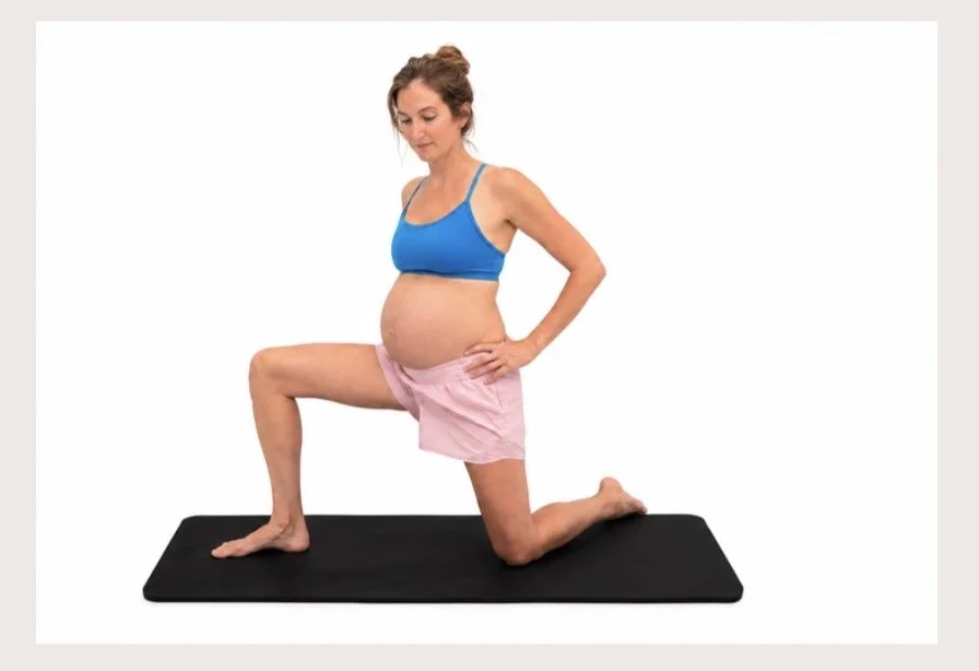 Pregnant woman doing lunge exercise on black yoga mat in bright studio.