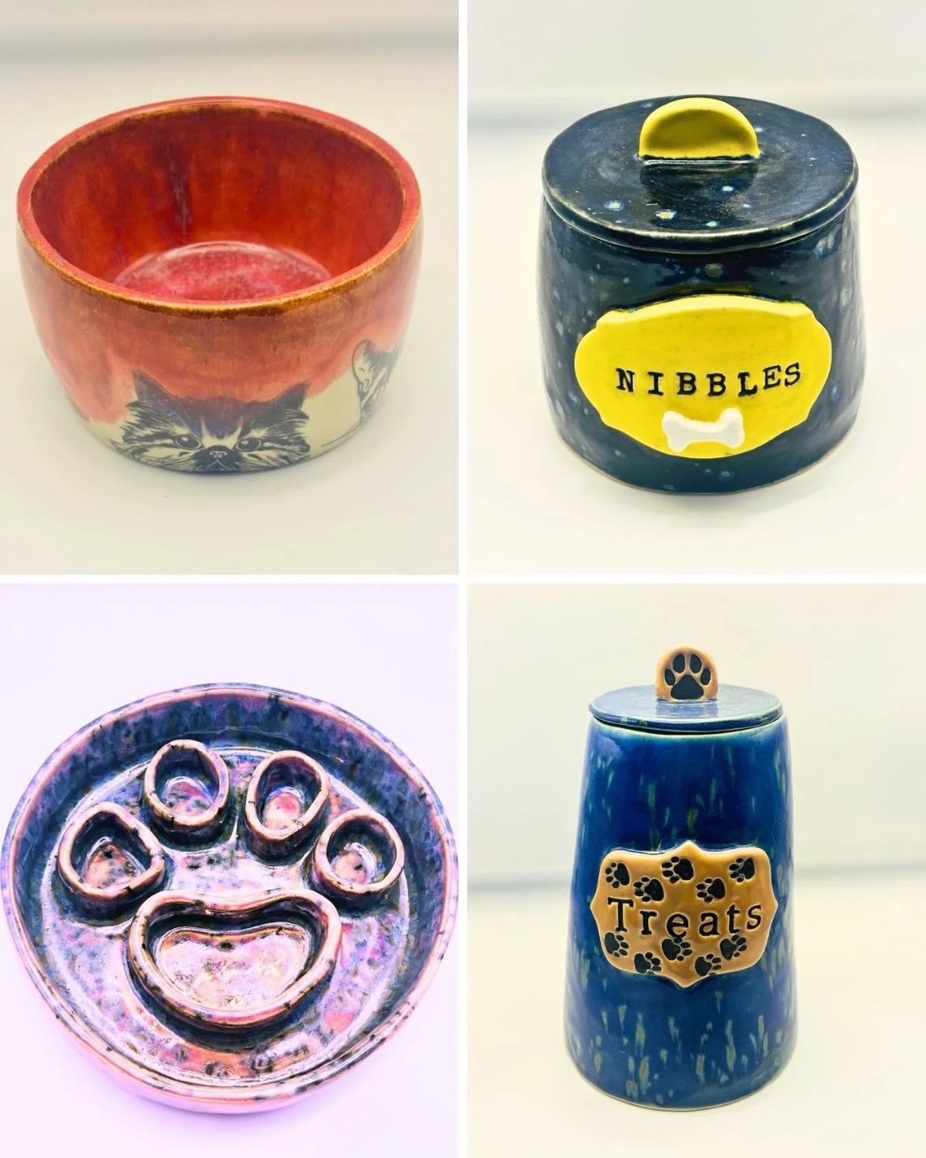 Four ceramic pet-themed containers and decorative items, including a red bowl with cat face design, a black jar with yellow labels reading 'Nibbles' and paw prints, a purple and blue paw print dish, and a blue container with a paw print label 'Treats'