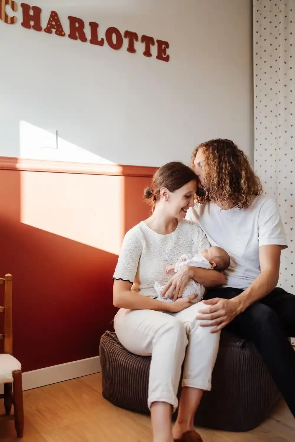 Papa et maman serrés l’un contre l’autre avec leur nouveau-né dans les bras, photo de naissance lifestyle à Villeneuve-d’Ascq