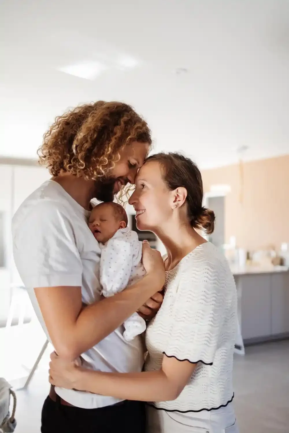 Parents front contre front, leur nouveau-né endormi contre eux, séance naissance à domicile à Villeneuve-d’Ascq