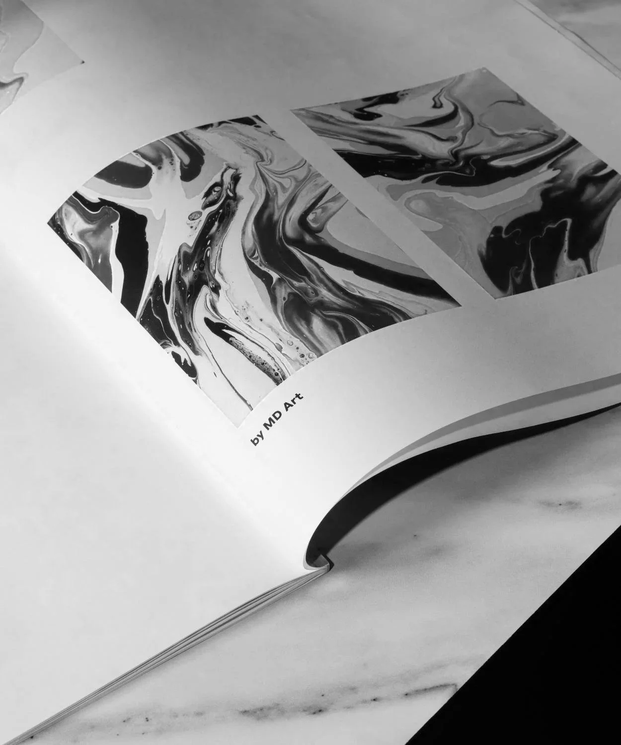 Open book showing black and white abstract art with the text "by MD Art".