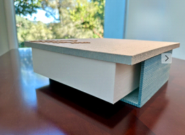 Close-up of a plain cardboard box on a wooden surface near a window