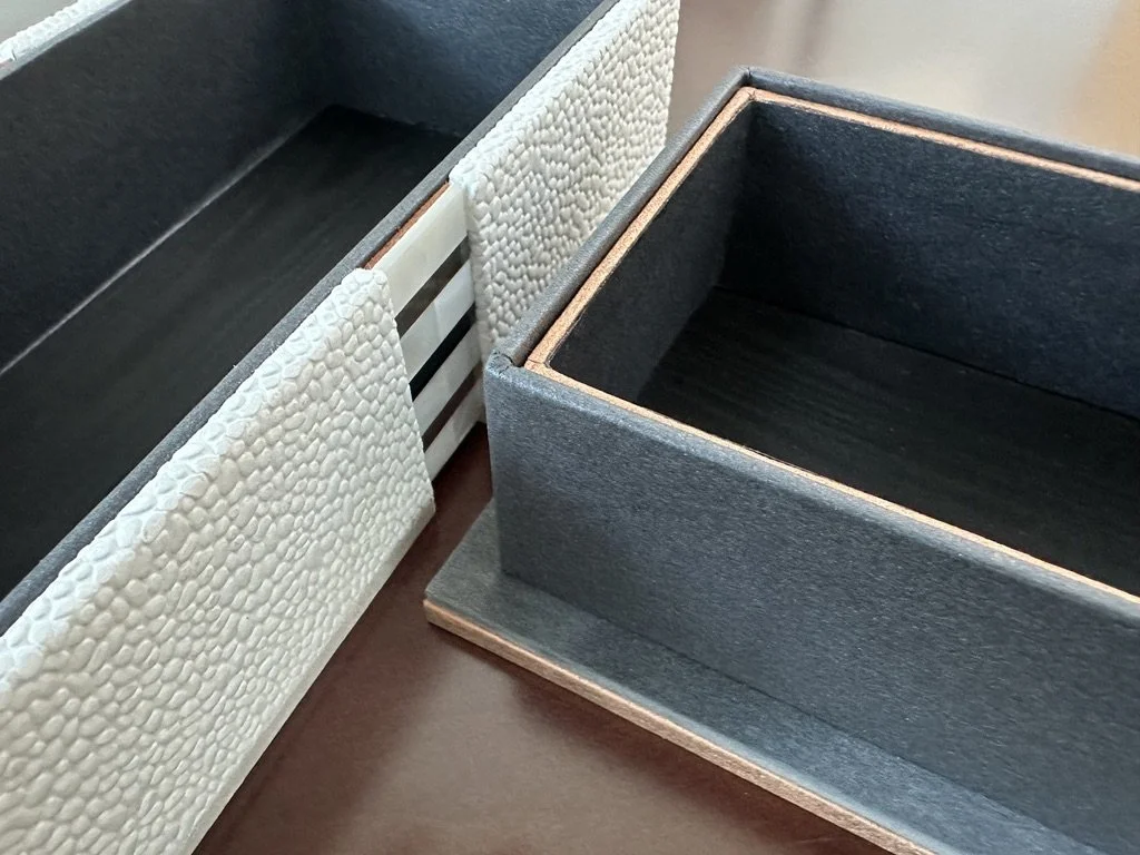 Close-up of black storage box and textured beige fabric panels on a furniture piece.