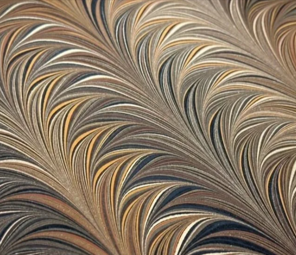 Marbled paper with swirling patterns in beige, brown, and black tones.