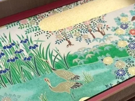 Decorative artwork depicting a natural landscape with animals, plants, and a pond in a traditional Asian style.