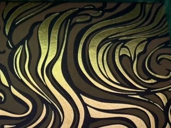 Close-up of a patterned surface with swirling black and green lines.