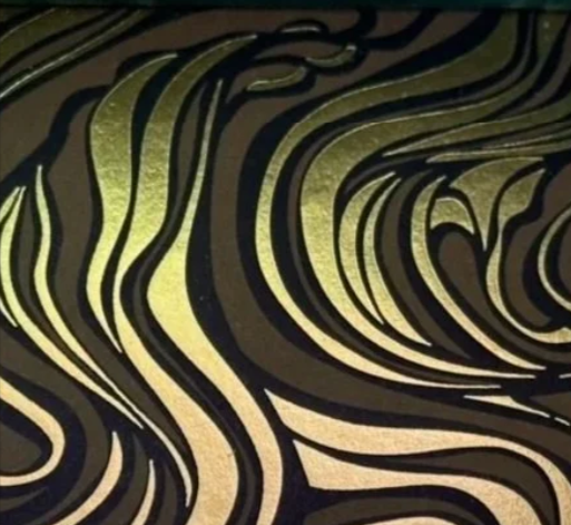 Abstract pattern with black and gold swirling lines.