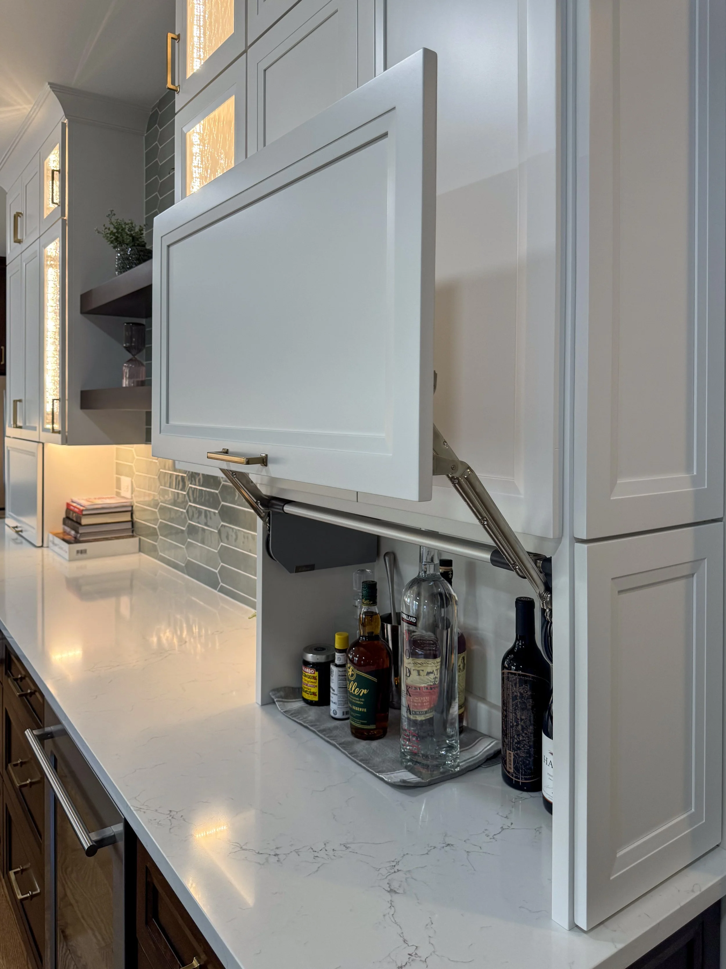 Hidden Beverage Station & Appliance Garage  |  Elevate your entertaining space. This custom lift-up appliance garage pulls double duty as a hidden cocktail and liquor station. Equipped with a premium vertical-lift mechanical door, it keeps your top-s