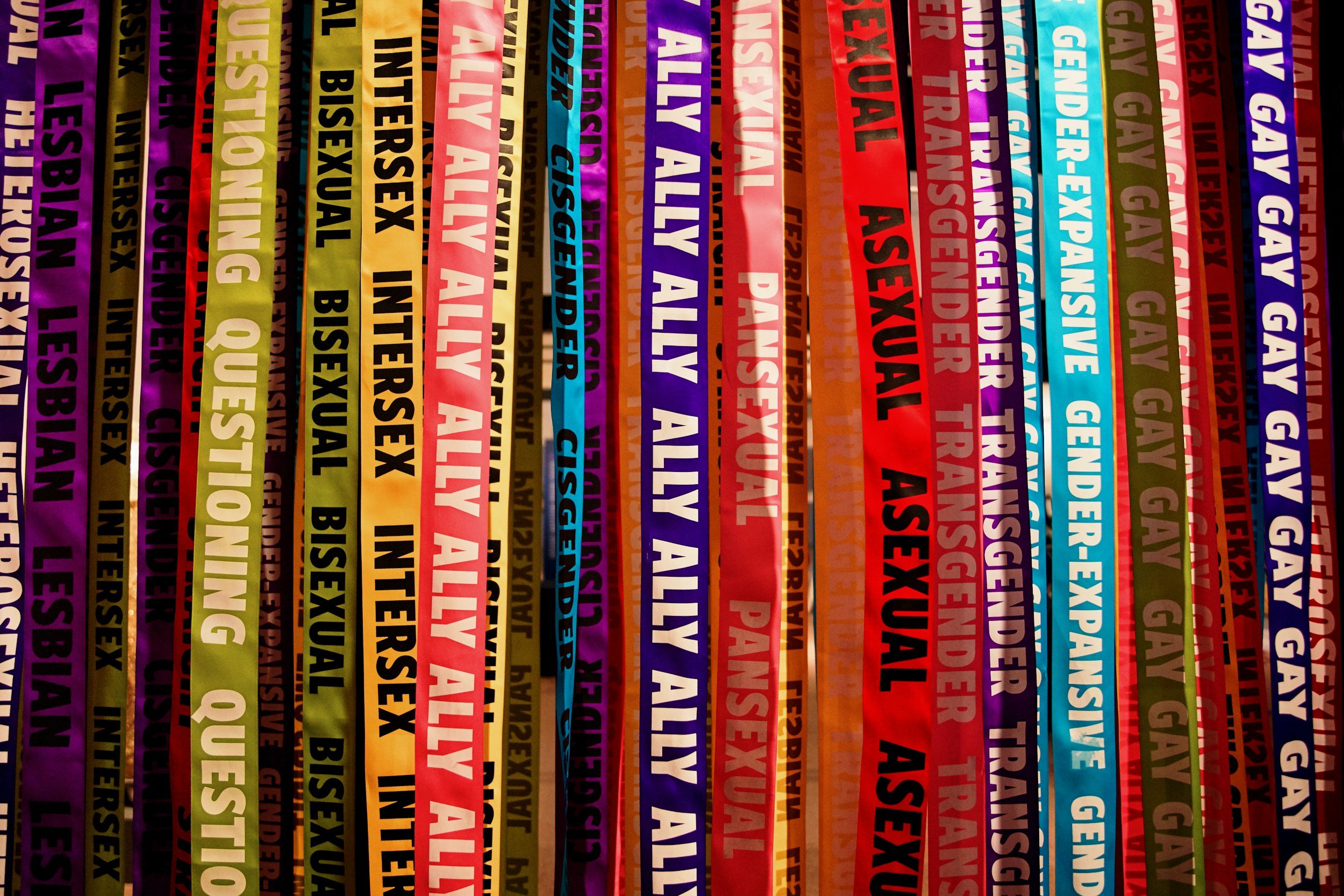 Colorful ribbons with various transparency, each with bold black or white text of different words and phrases.