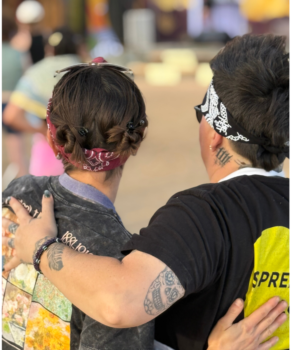 People wearing bandanas, tattoos, and casual clothing, standing close together in a crowded indoor setting.
