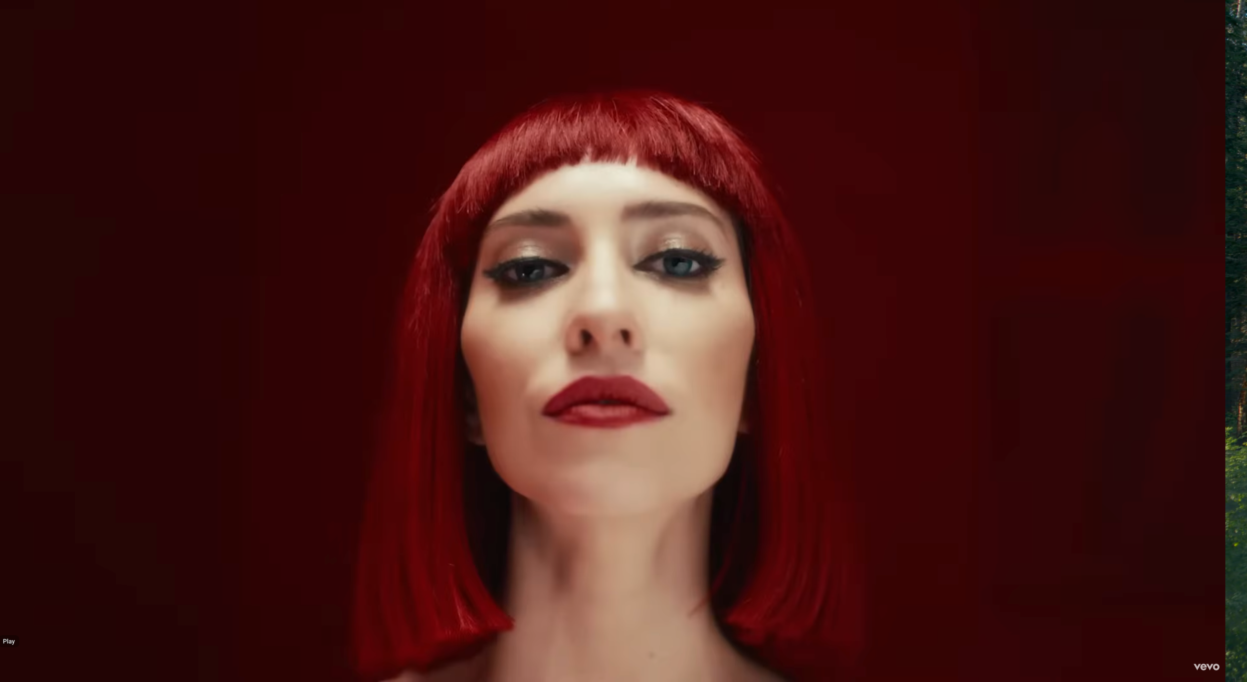 In My Blood - The Veronicas, still from music video. Features woman in red wig staring at camera with intense stare.