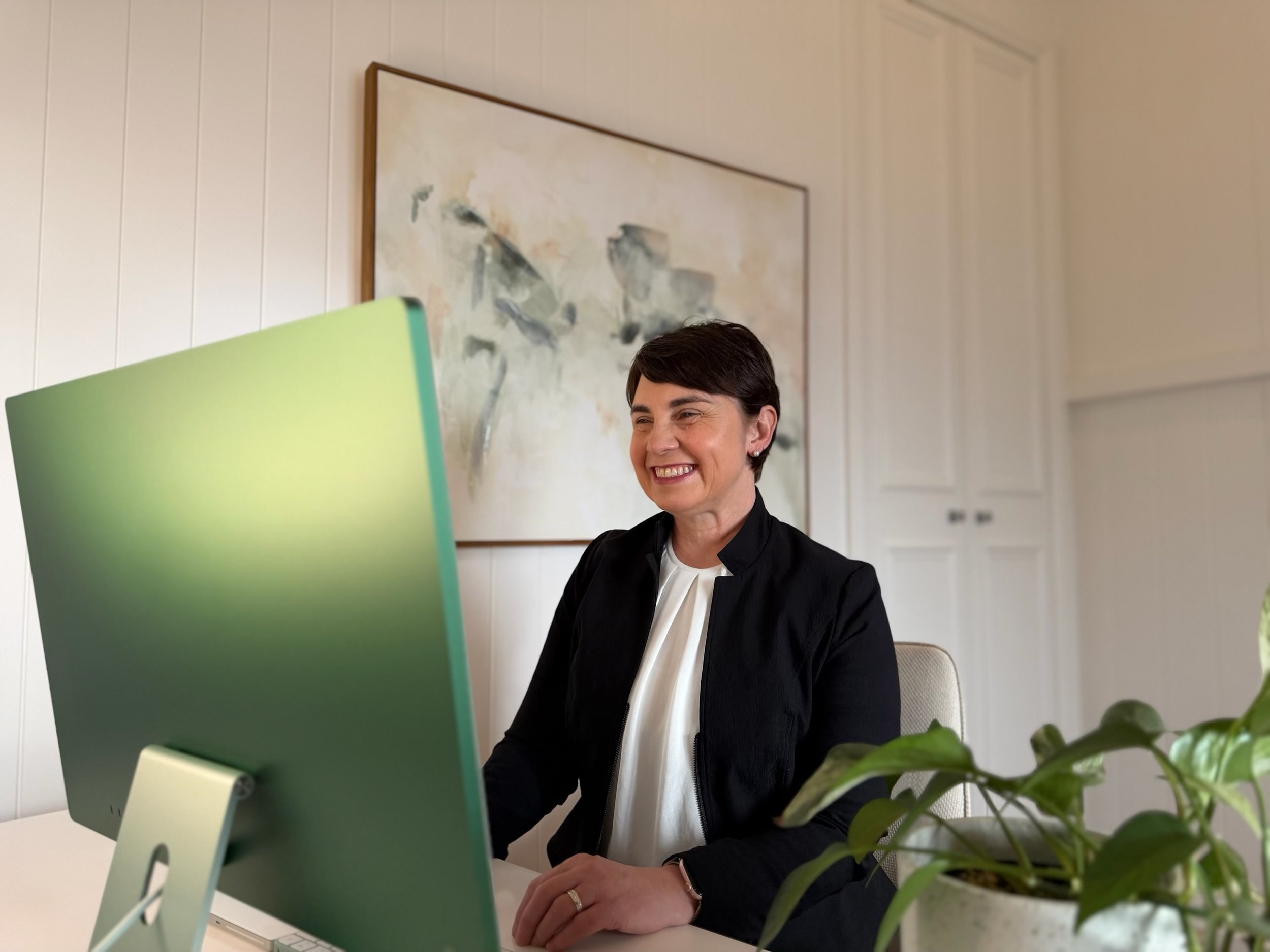 Dr Julie Cichero sitting at a computer delivering online clinical supervision and mentoring in dysphagia.