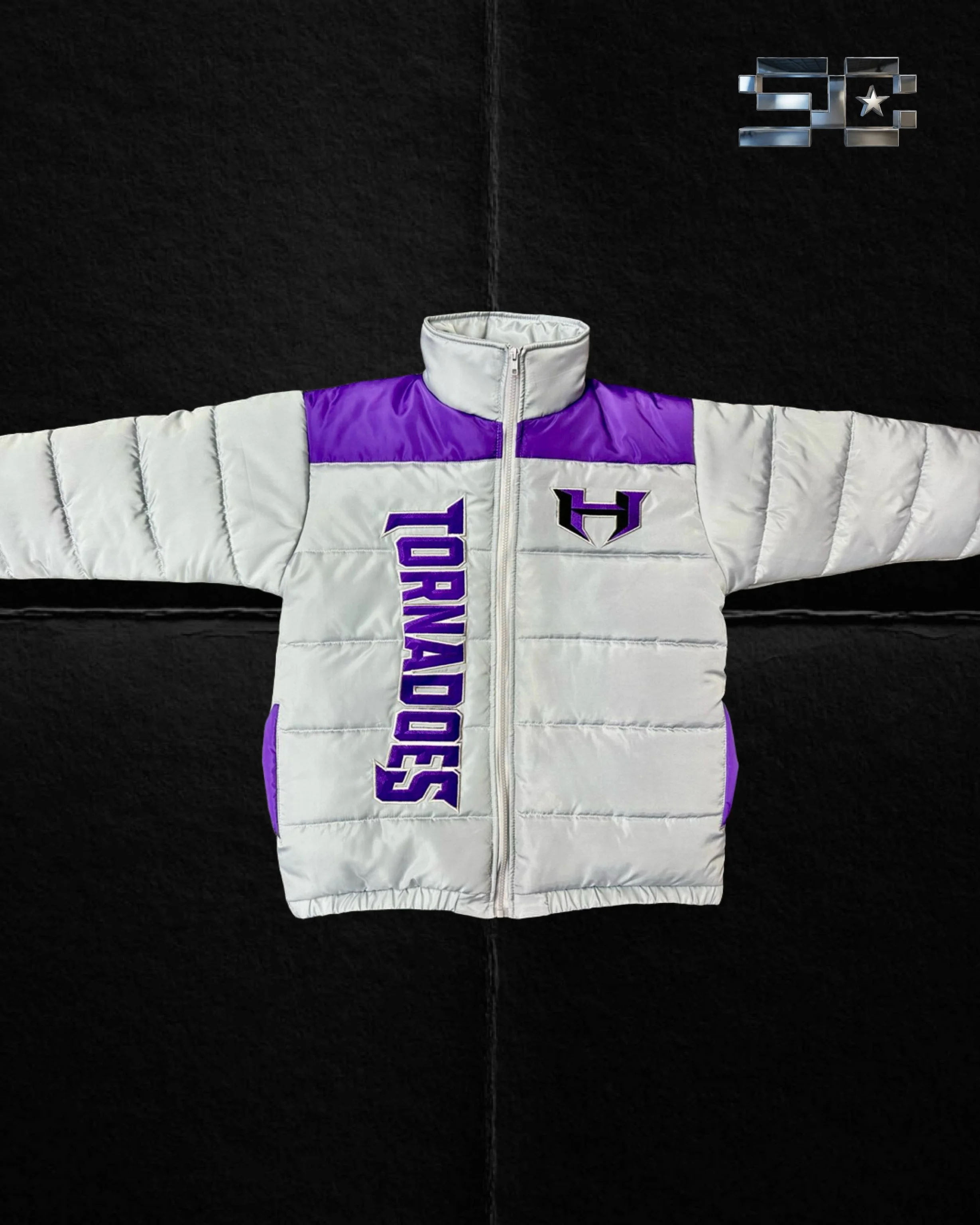 A white and purple hockey jacket with a front zipper, spread out on a black surface, with a logo resembling a shield on one side and the words "SANDWICH" written vertically.