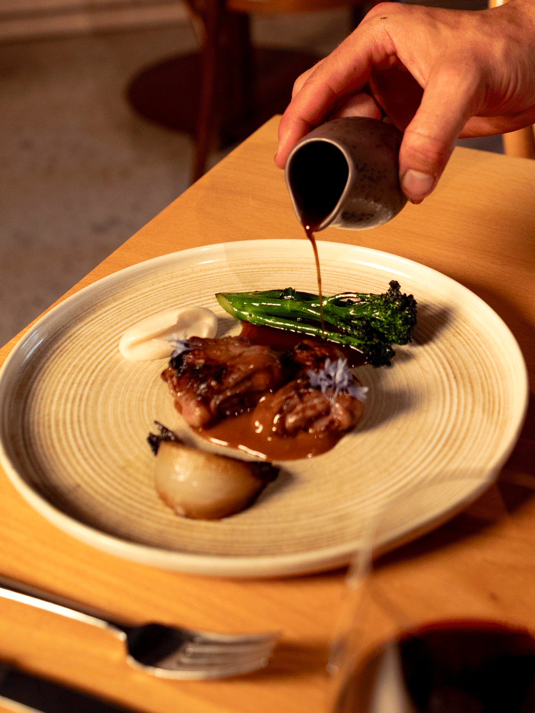 A new menu item of steak and veg at Aurora restaurant, with gravy being poured on top