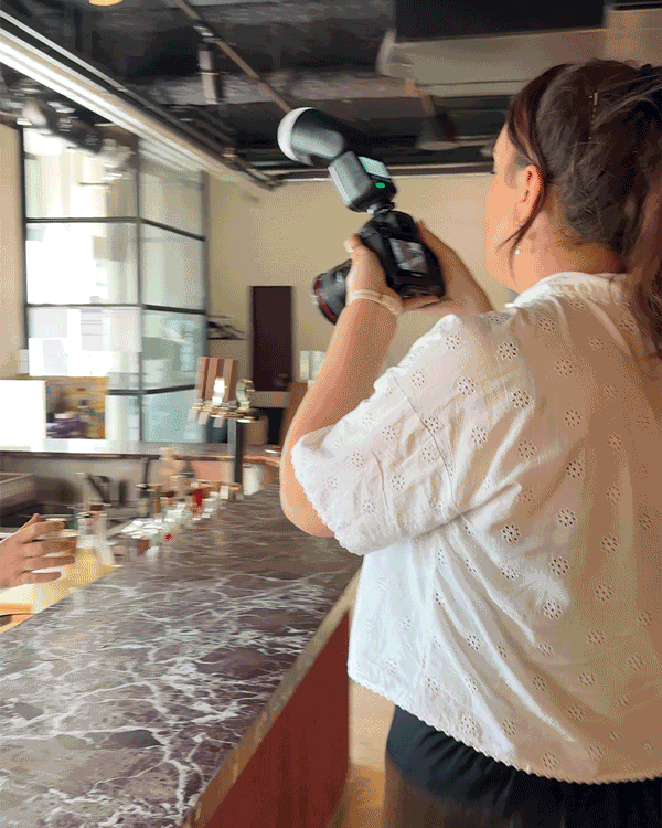 A gif of Rachel photographing a cocktail being prepared