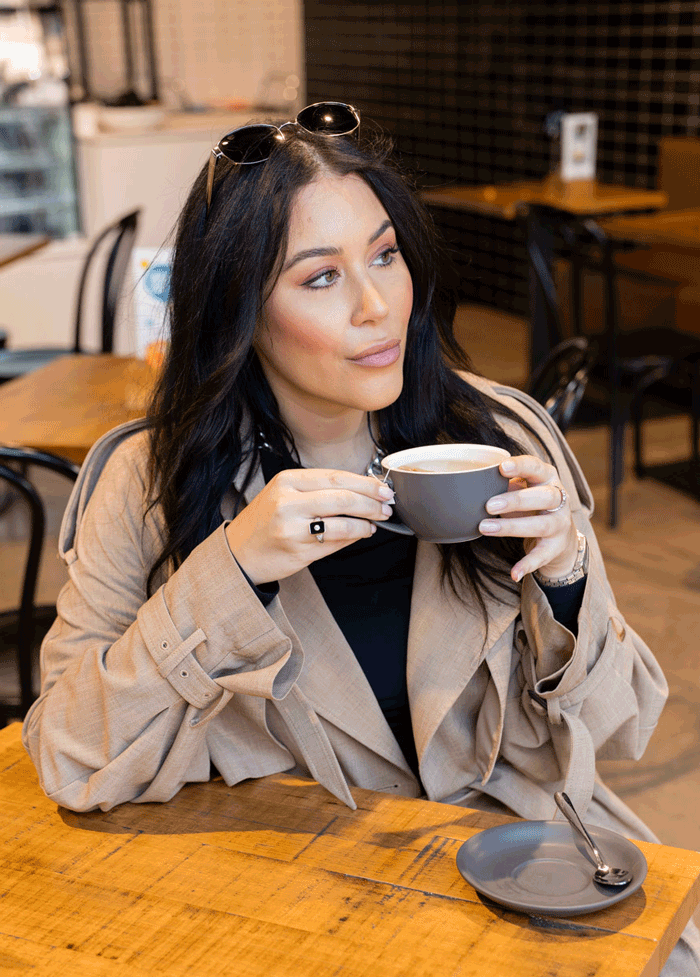 A woman sitting at a Funk cafe, drinking a tea