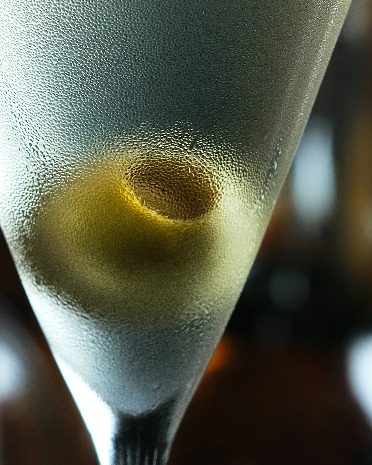 Close-up of a frosted glass with condensation on the surface and a dark liquid inside.
