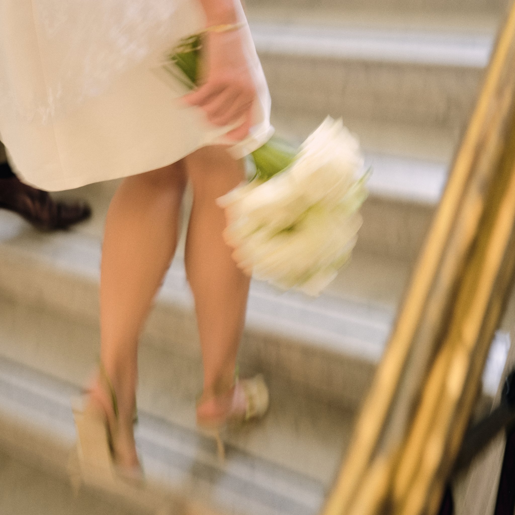 A person holding a bouquet of white roses, seen from the side.