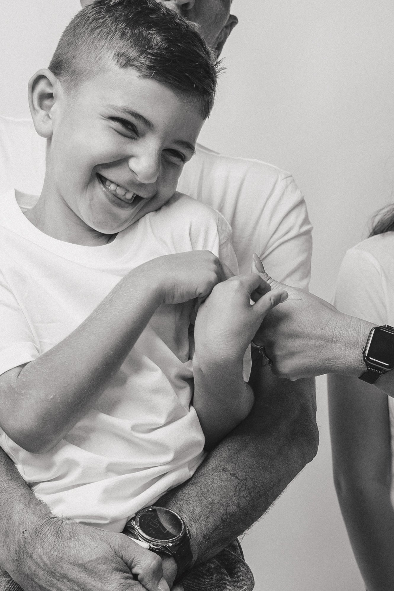 A young boy smiling while receiving a vaccination, with a healthcare professional administering an injection in his arm.