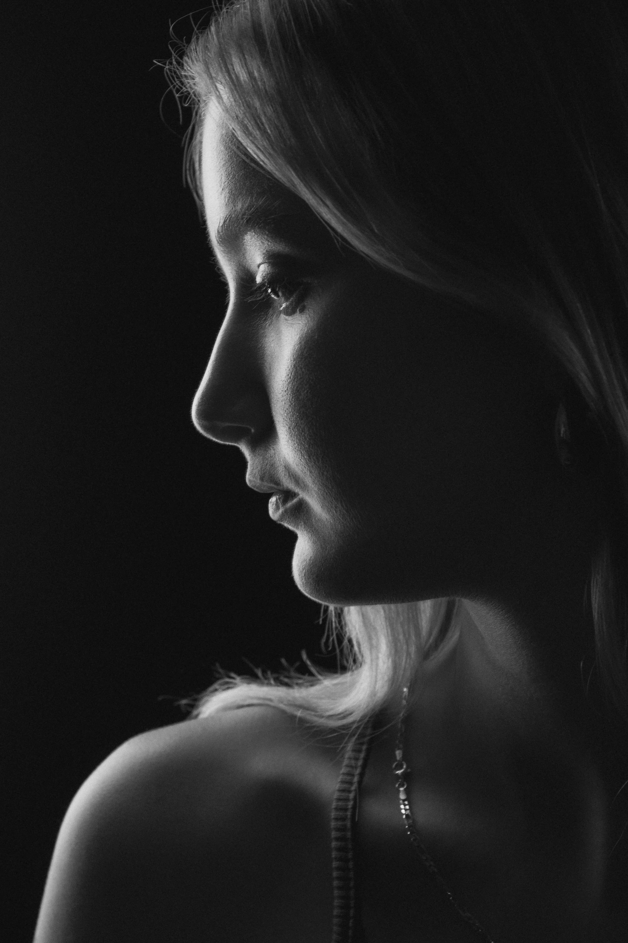 Black and white profile of a young woman with short hair, closed eyes, and a contemplative expression. fashion photography. portrait. profesional model. צילומי אופנה, נשיות, דוגמנית, צילומים בסטודיו, העצמה נשית, צילומי יופי