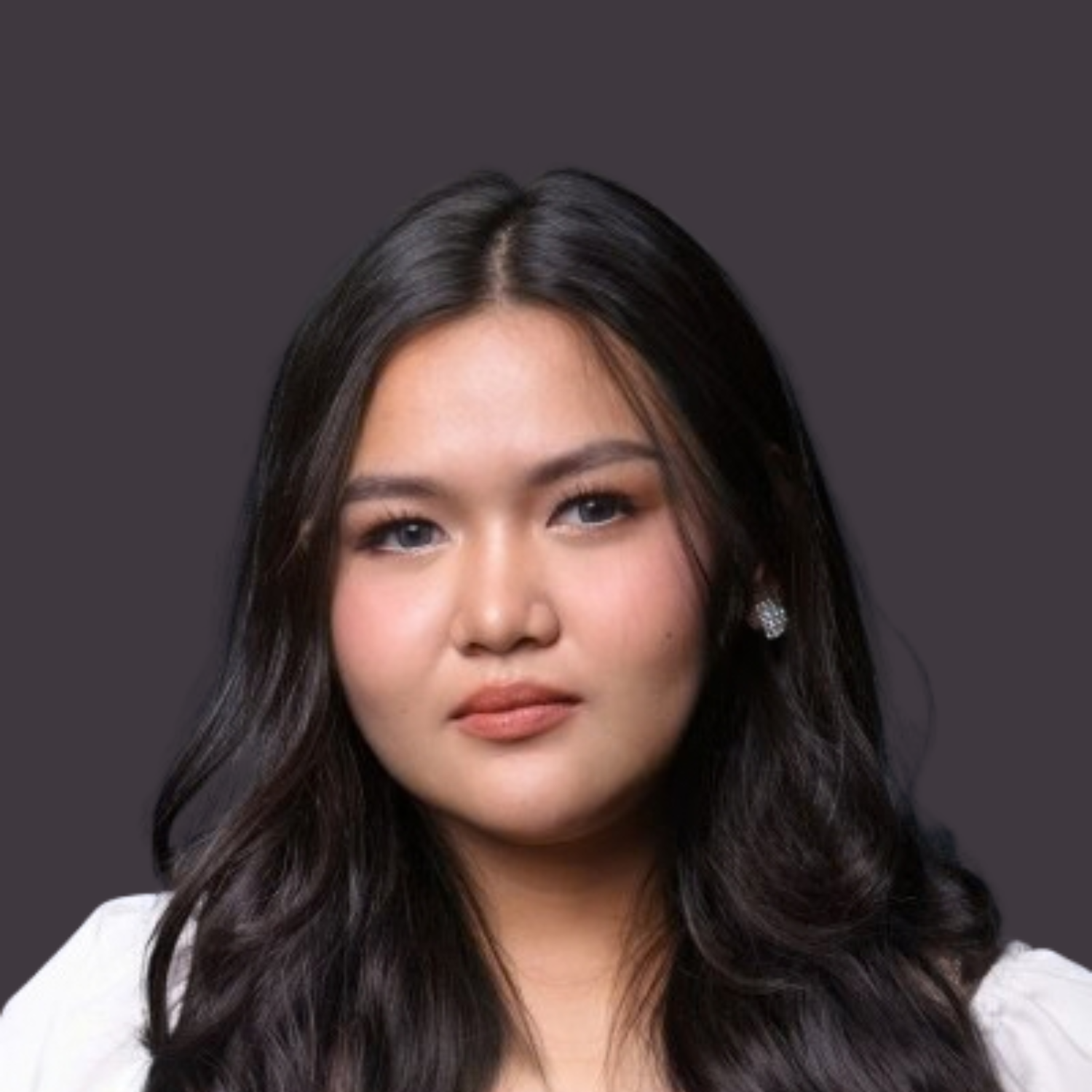 Close-up of a young woman's face with long dark hair, wearing earrings, against a dark background.