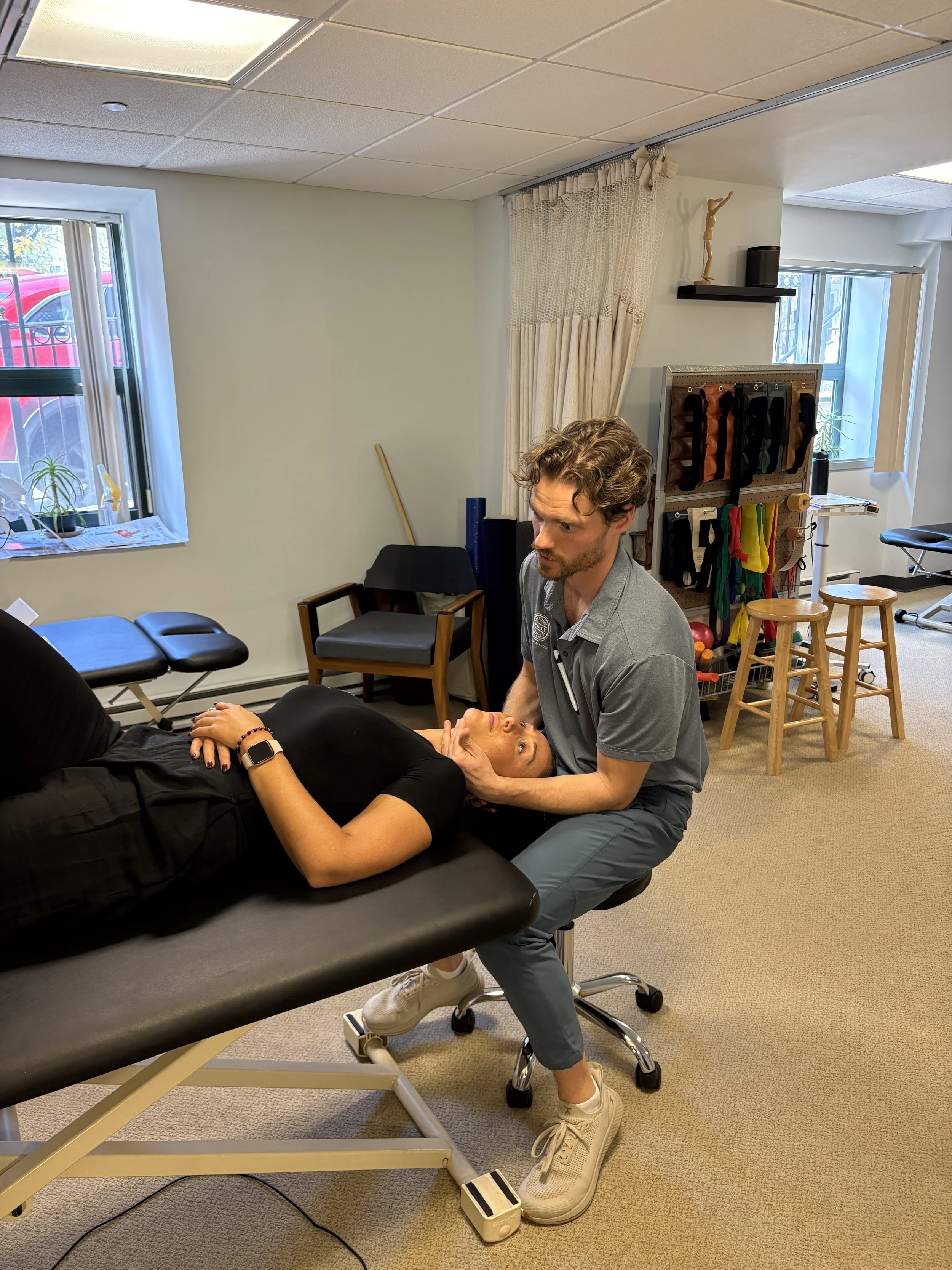 Physical therapist performing a cervical treatment on patient