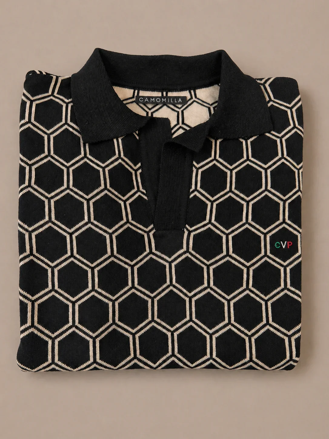 Camisa negra con patrón de hexágonos blancos, puntera, etiqueta que dice 'Camomilla', y logo de 'CVP' en la esquina