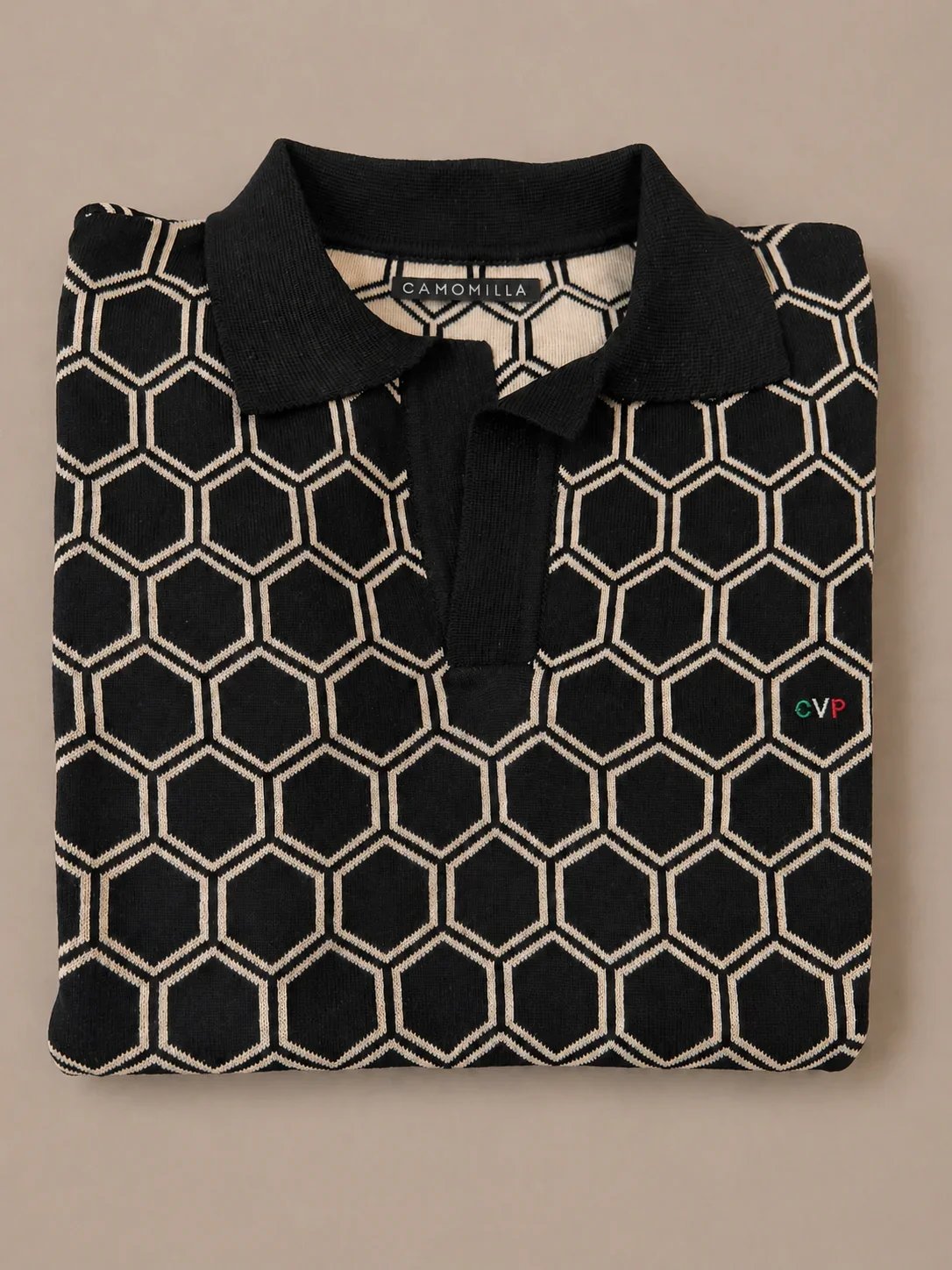 Camisa negra con patrón de hexágonos blancos y etiqueta que dice 'Camomilla' en el interior del cuello.