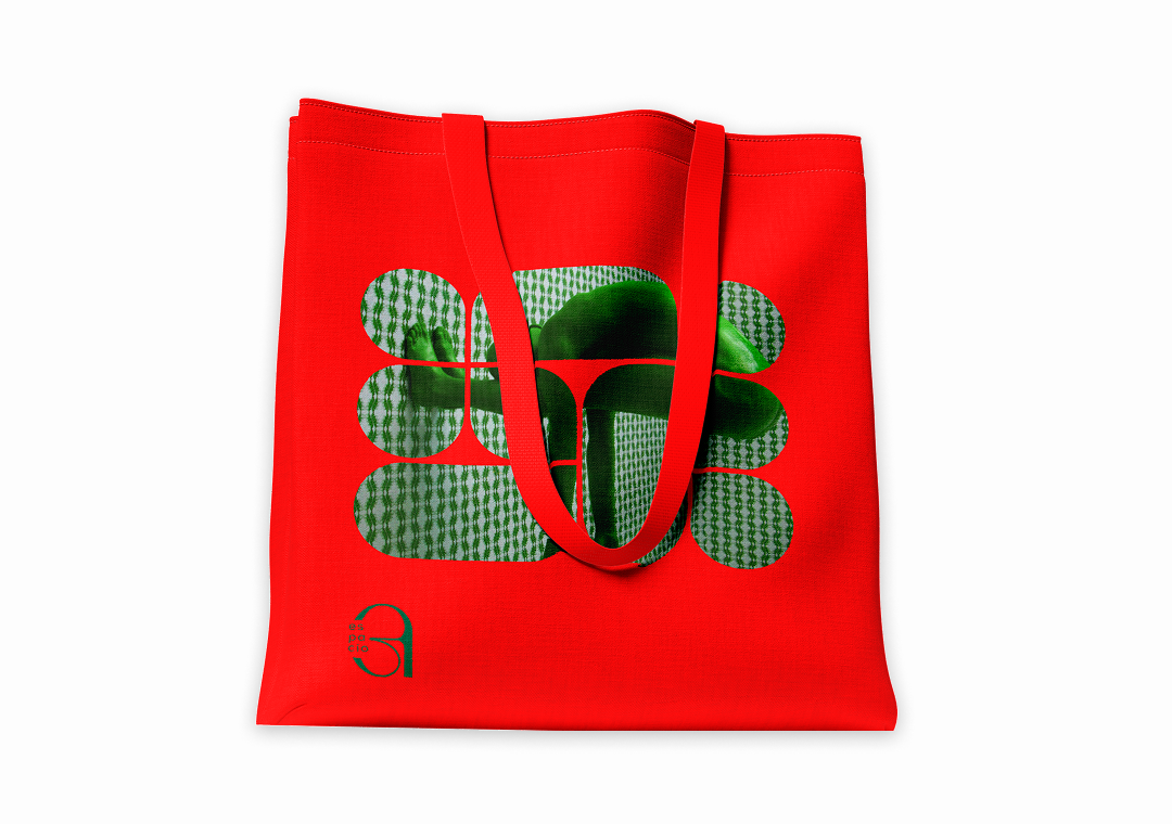 Bolso rojo con diseño gráfico verde y negro, y asas largas.