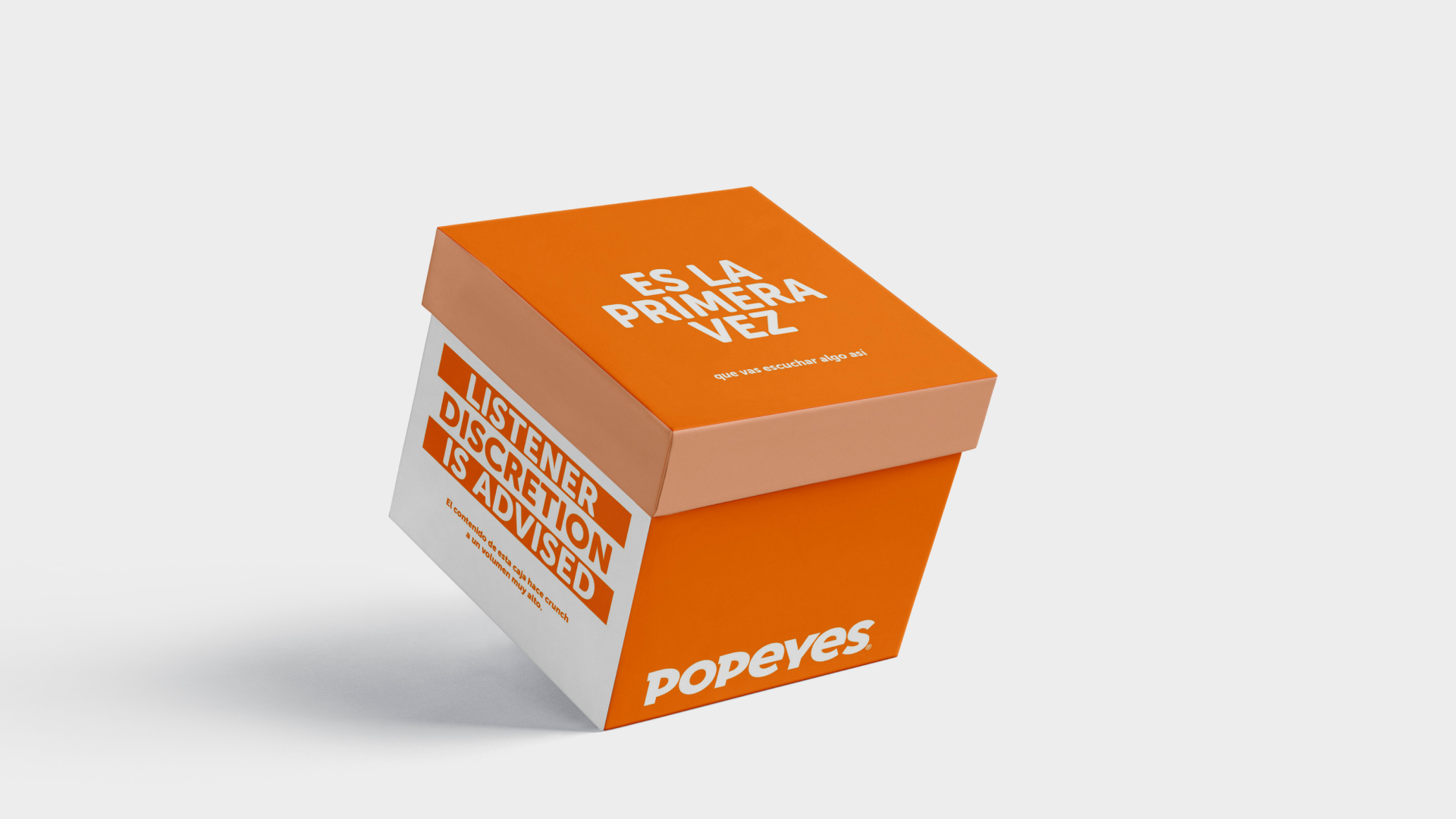 Caja de comida de Popeyes con texto en español que dice "Es la primera vez" y una advertencia de contenido