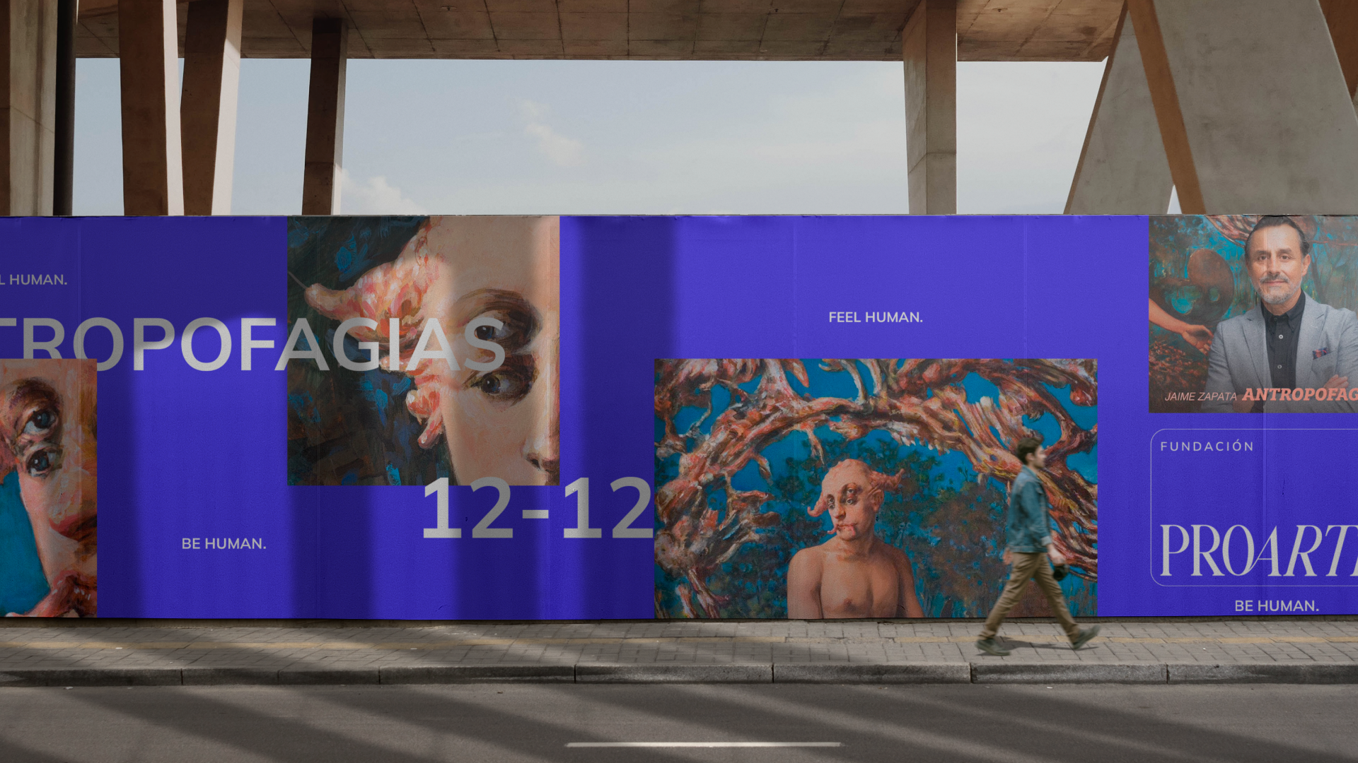 Cartel publicitario sobre la exposición de arte sobre antropofagia, con pinturas y retratos, y un hombre caminando frente a él en la acera.