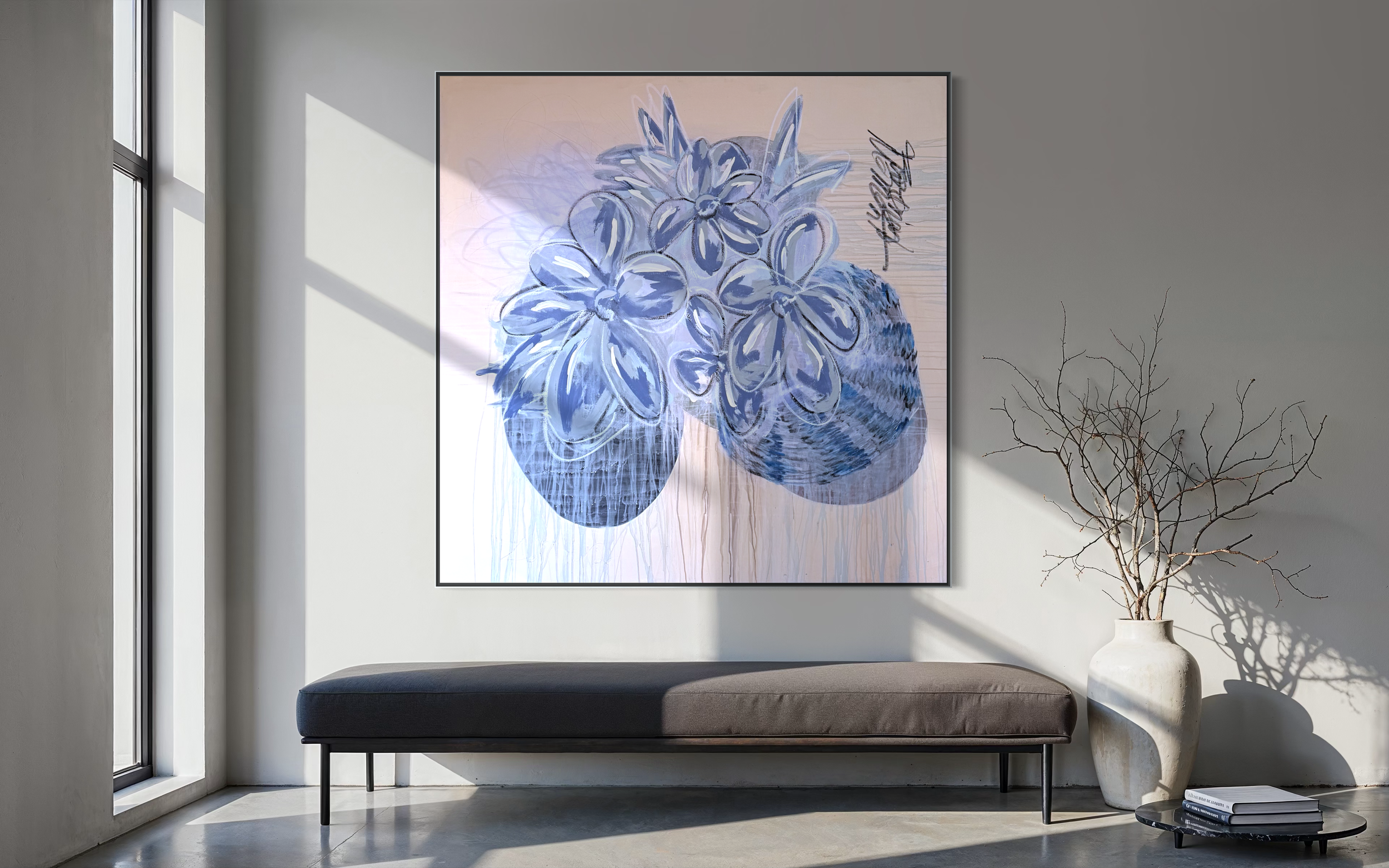 A modern interior with a wall-mounted artwork of a floral illustration, a window casting natural light, a long black bench below the artwork, a large white vase with bare branches to the right, and a small black coffee table with books underneath the branches.