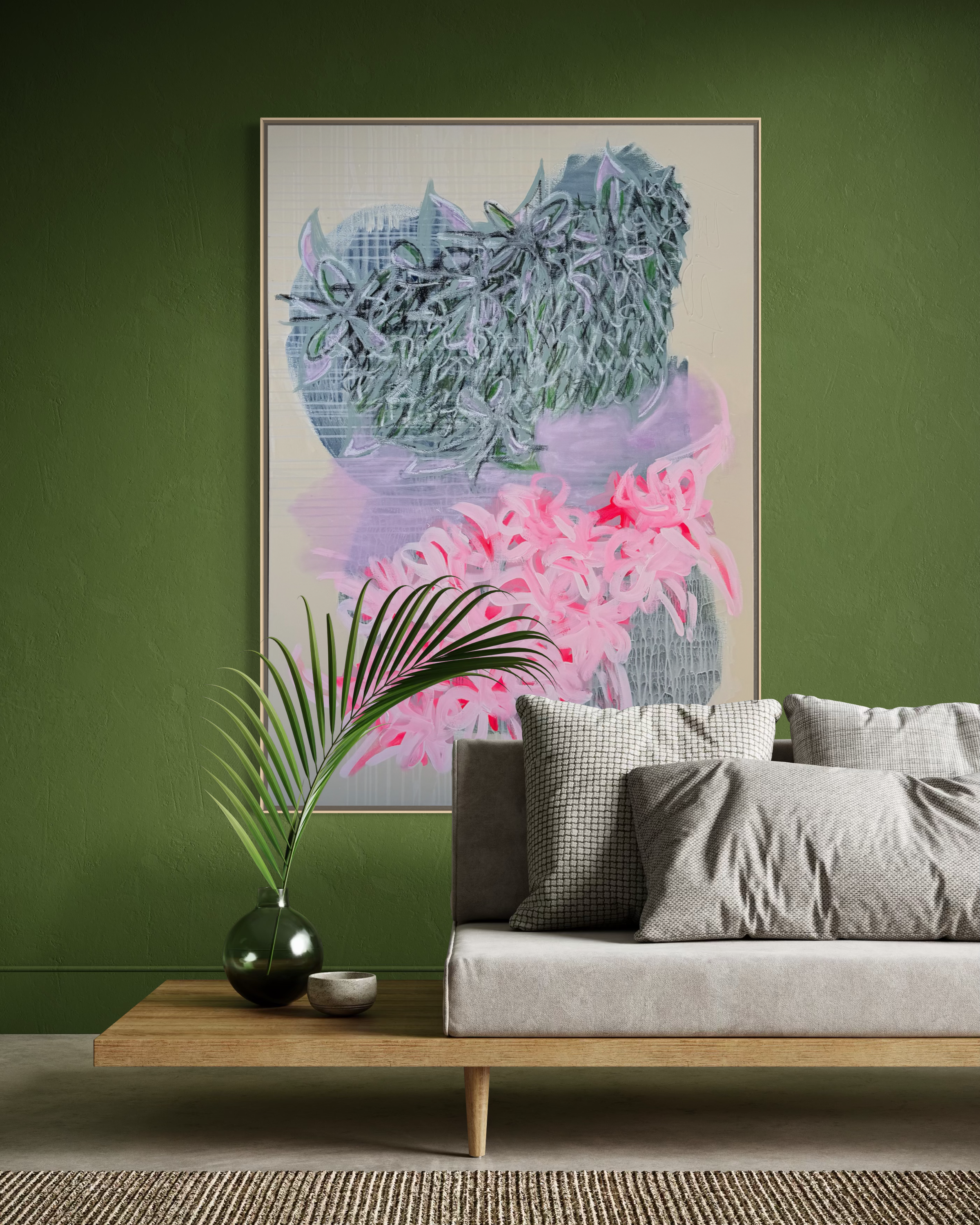 Room with a green wall, abstract floral painting, beige sofa with patterned pillows, wooden coffee table with a dark green vase and smaller pottery, striped rug.