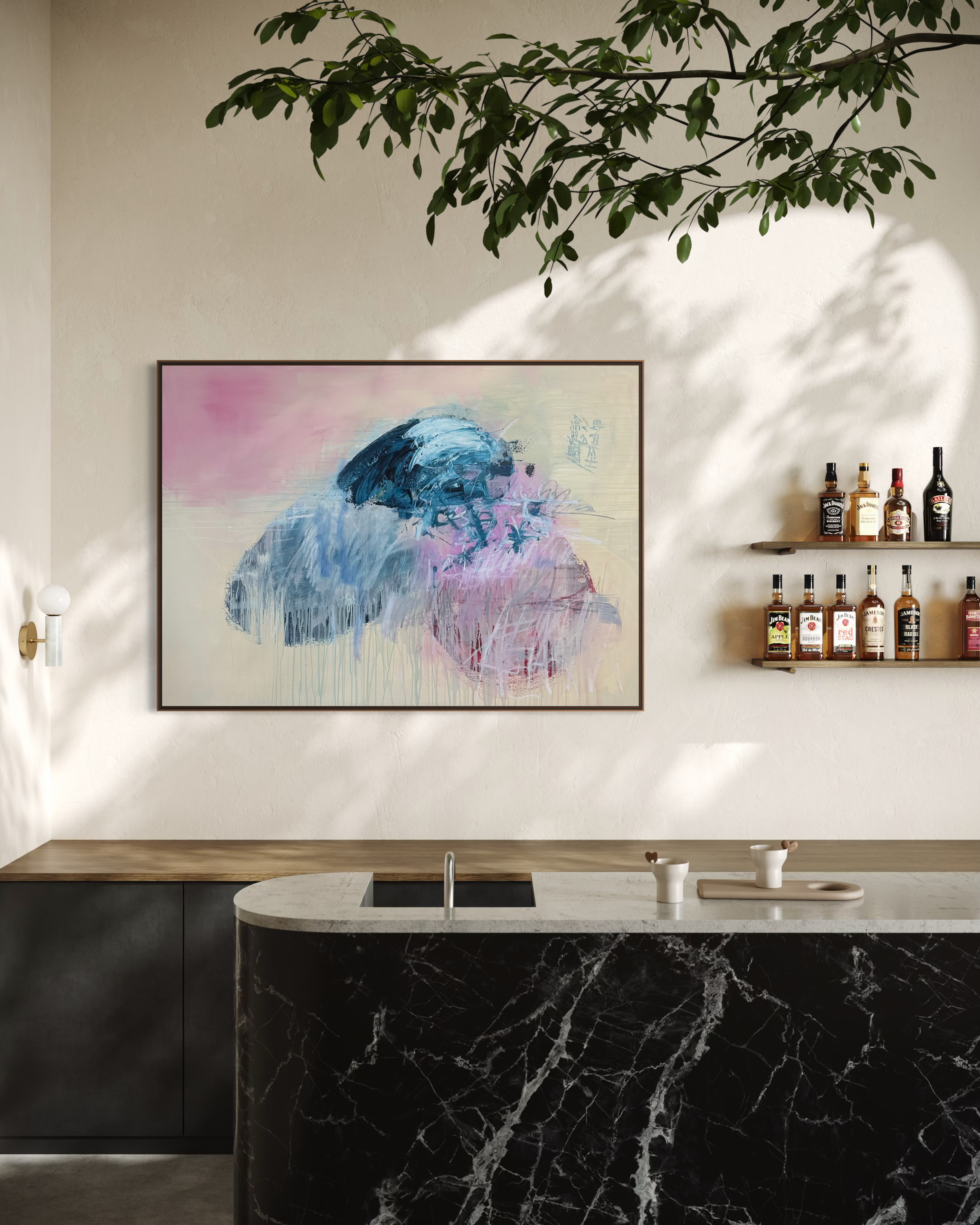 A modern kitchen with a black marble island, white countertop, and a wall-mounted shelf with various bottles of alcohol. There is abstract art on the wall and a branch with leaves extending from the ceiling, casting shadows on the wall.