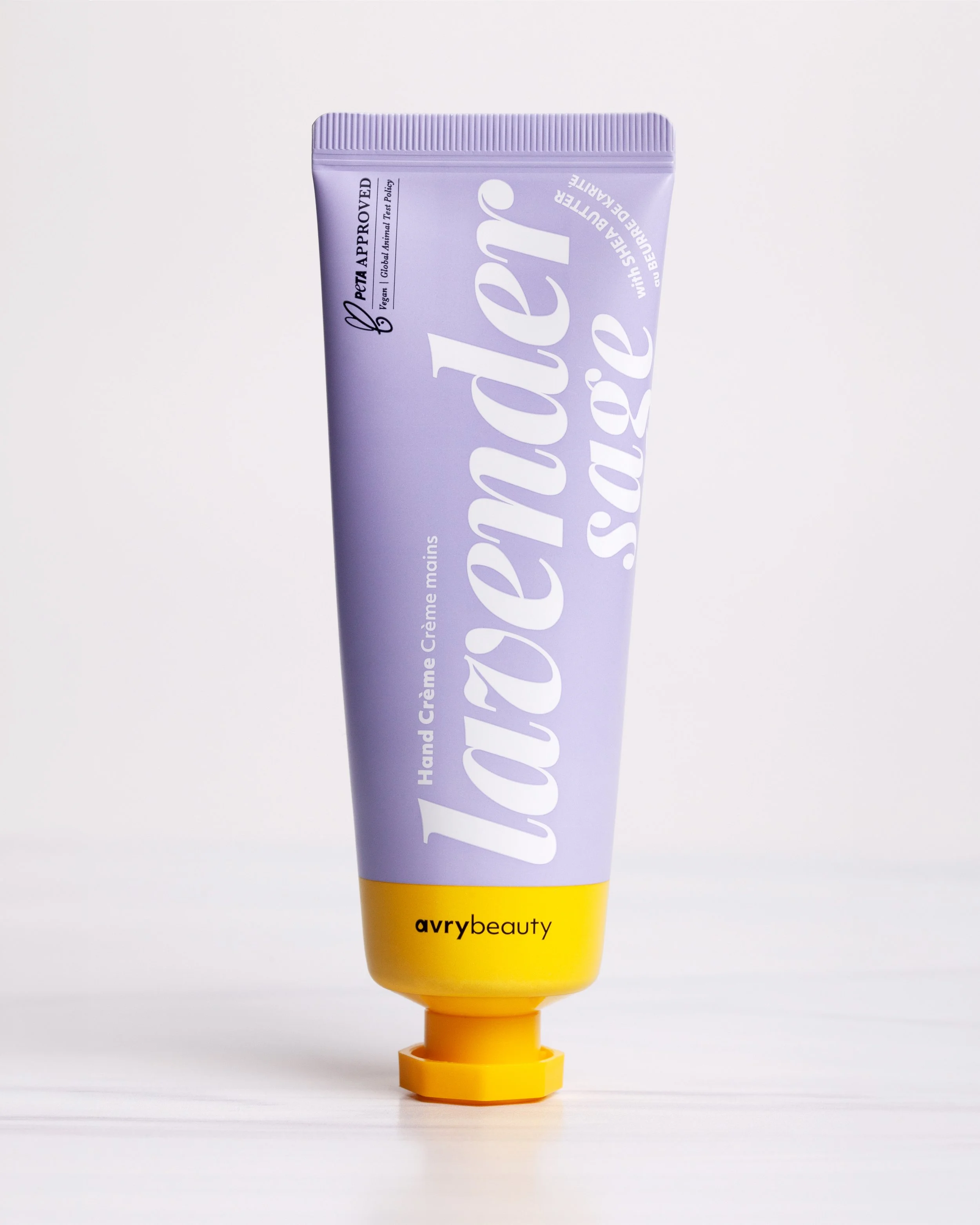 A tube of Avry Beauty hand and creme with shea butter on a white surface with a pale background