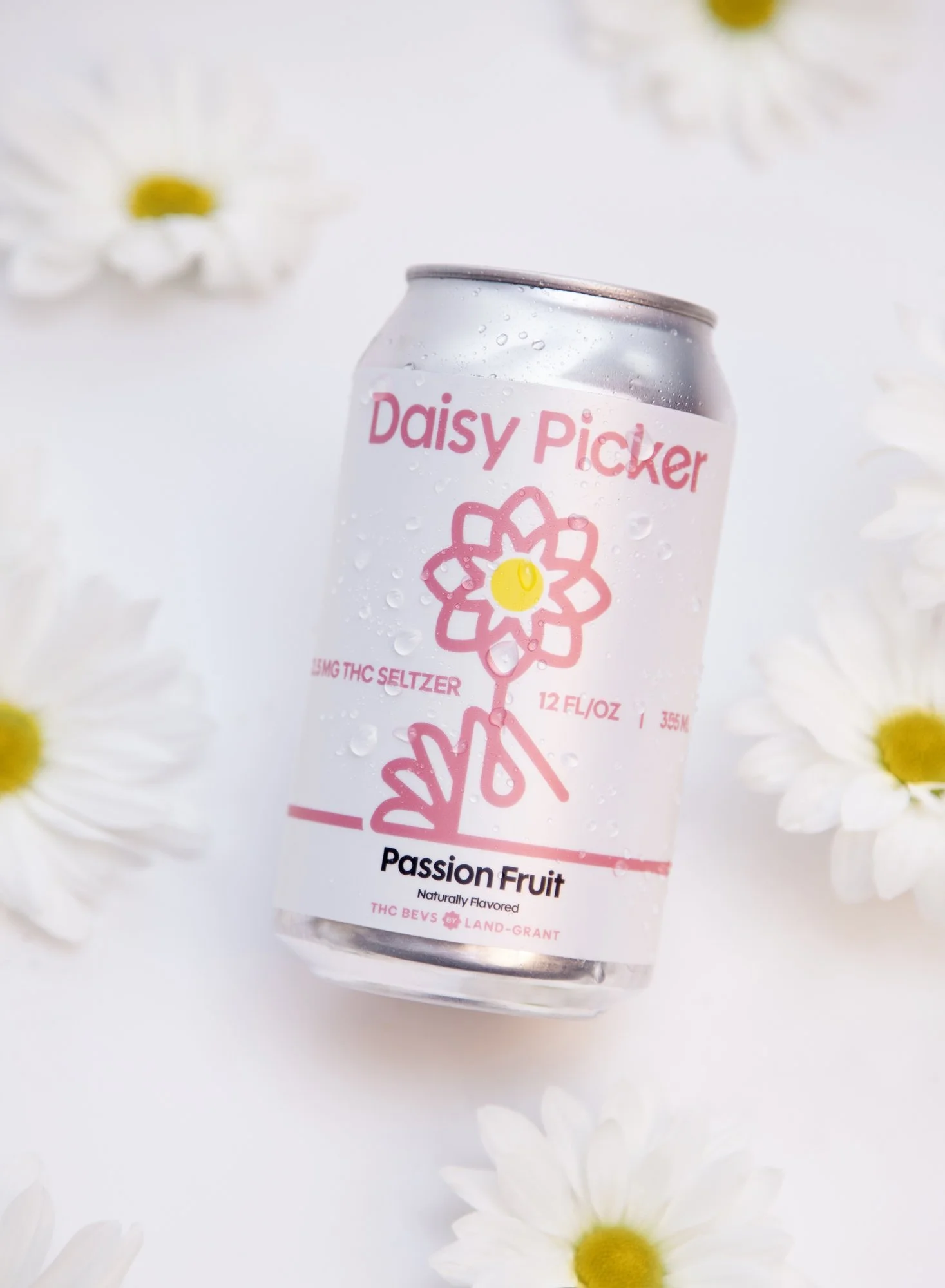 A can of Daisy Picker Passion Fruit THC seltzer with daisies around it on a white background.