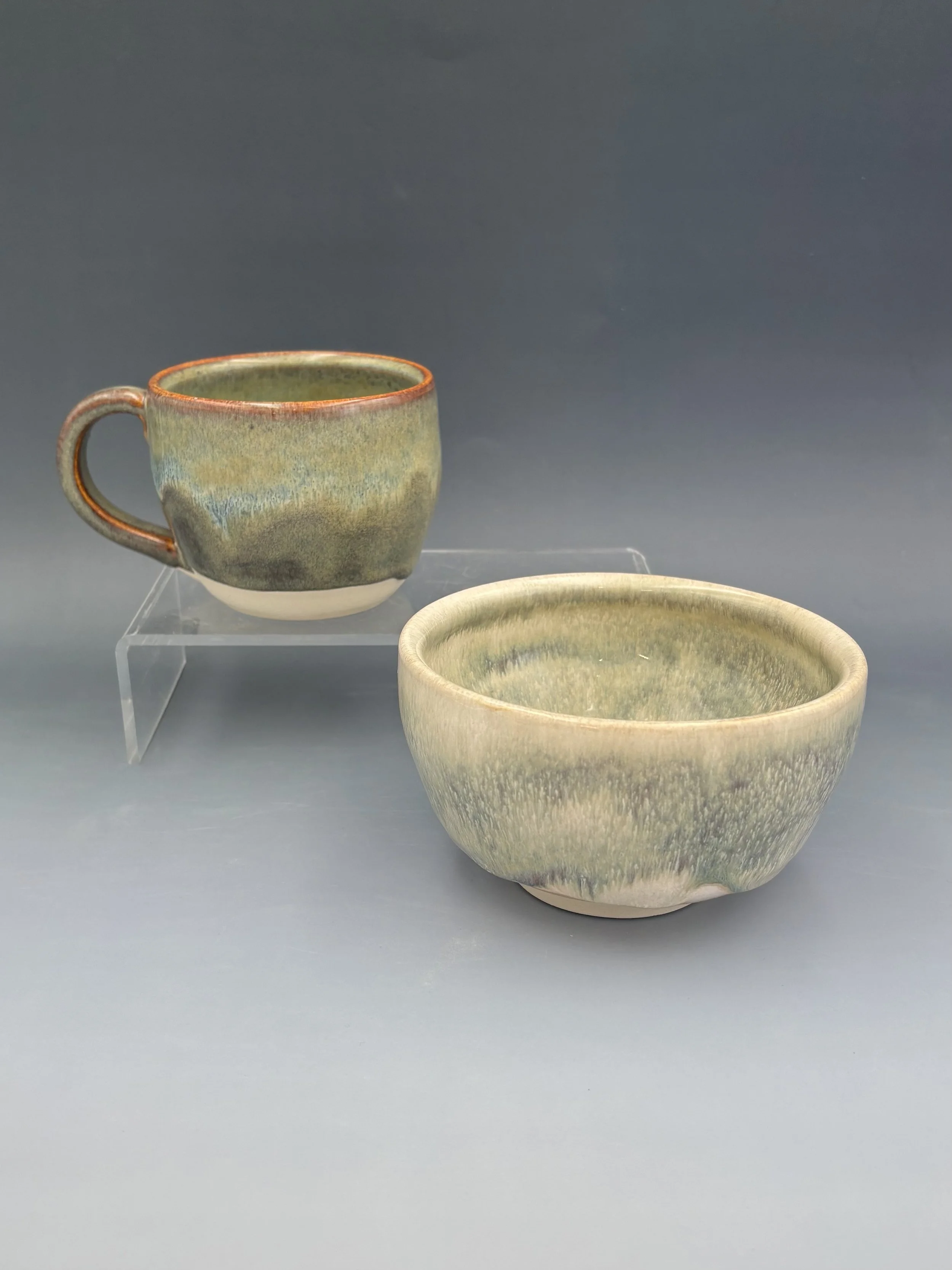 Handmade wheel-thrown ceramic mug and bowl by student Lisa Bowers in mottled green and rust glaze, made in Malenka Luckett's ceramics class
