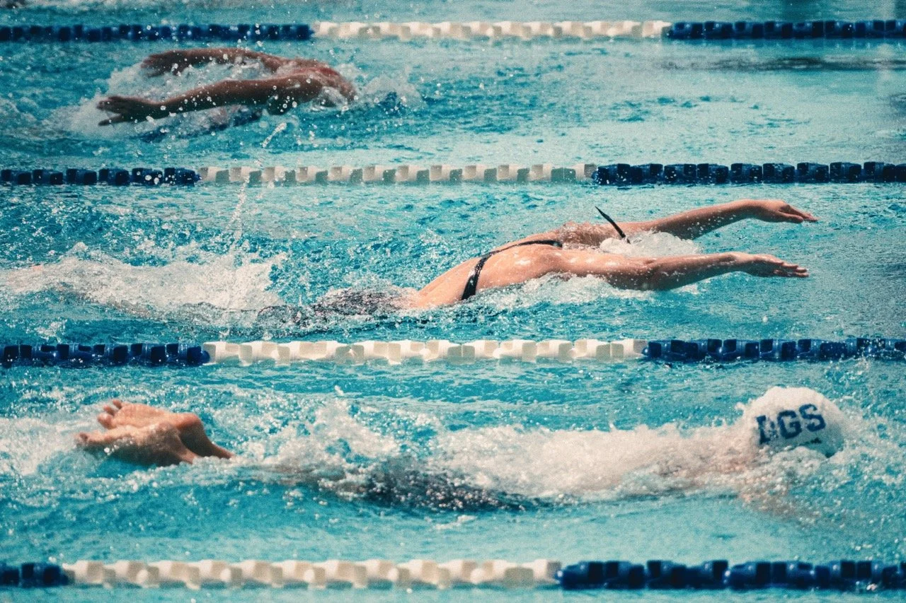 Swimmers competing in a swimming race in a swimming pool.