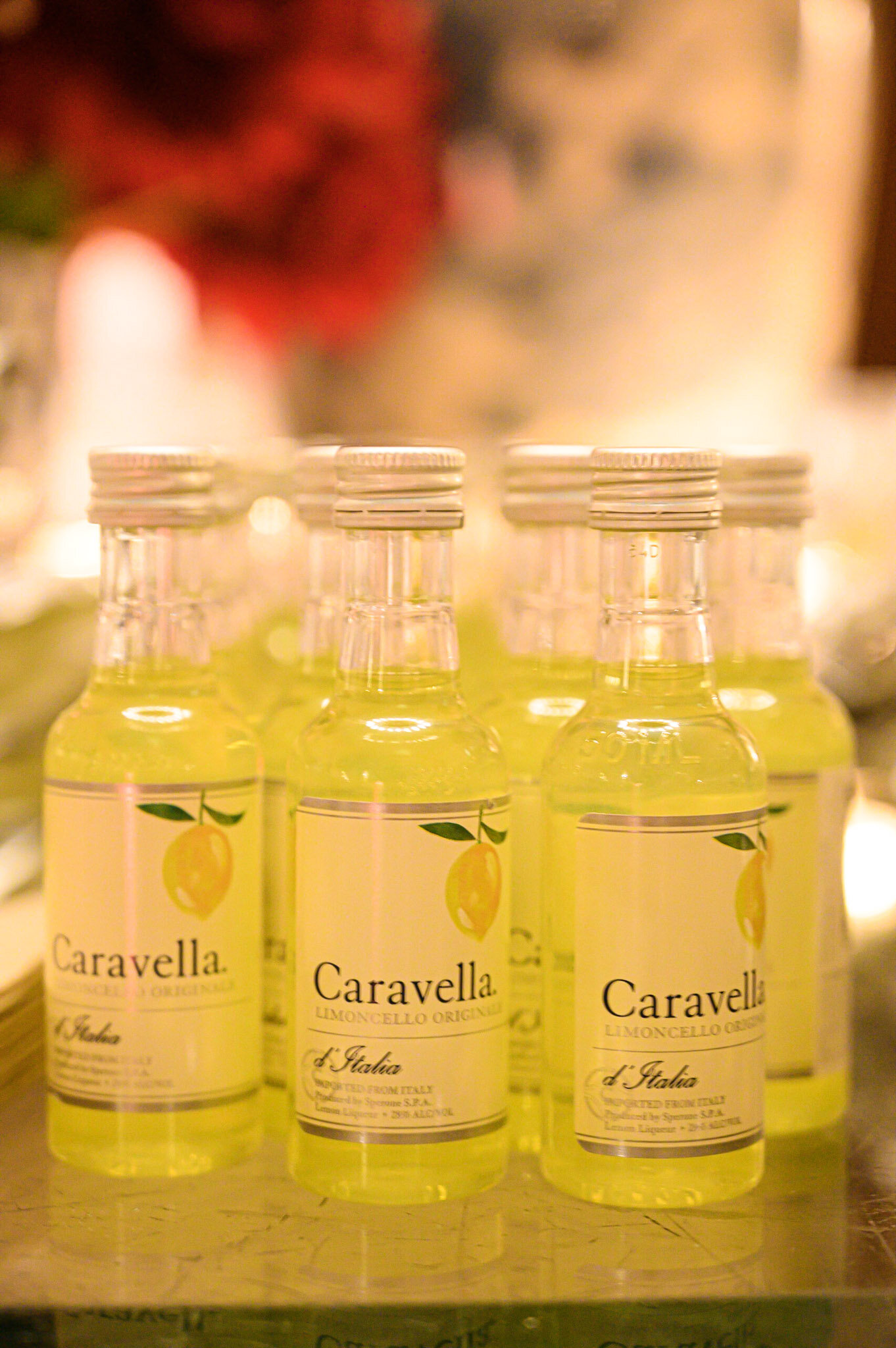 Several bottles of Caravella Lemoncello with yellow liquid and lemon illustrations on the labels, arranged in a row.