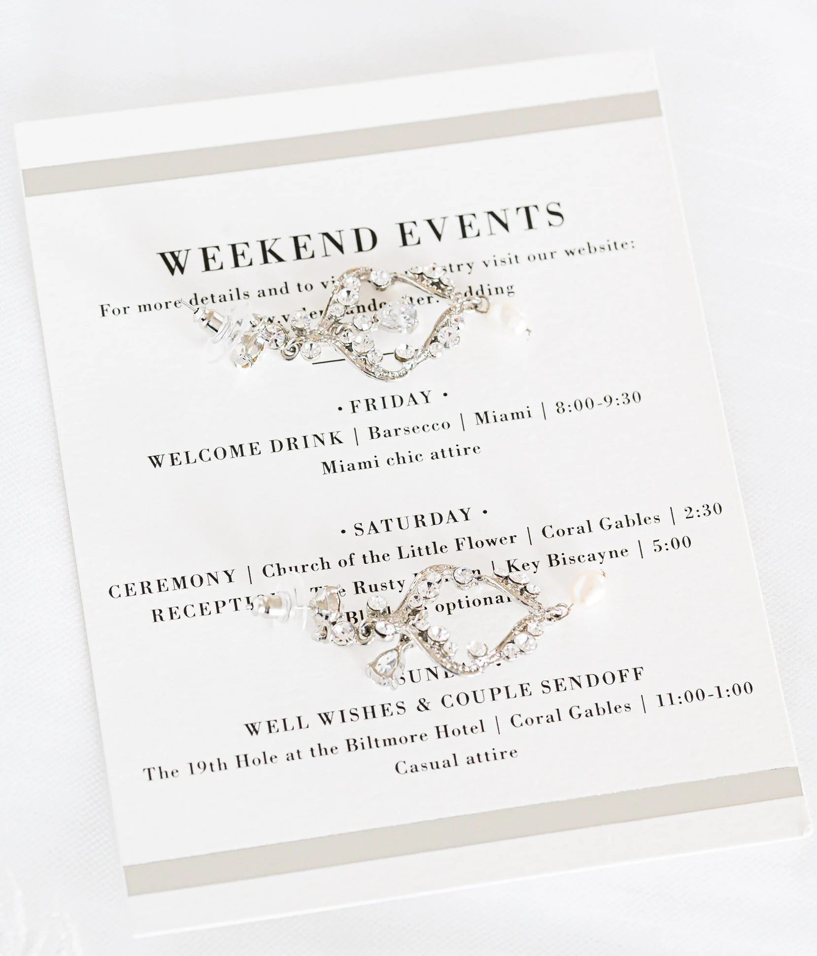 Wedding event schedule with details about the weekend's events, including Friday, Saturday, and Sunday activities, and a decorative brooch placed on top of the program.