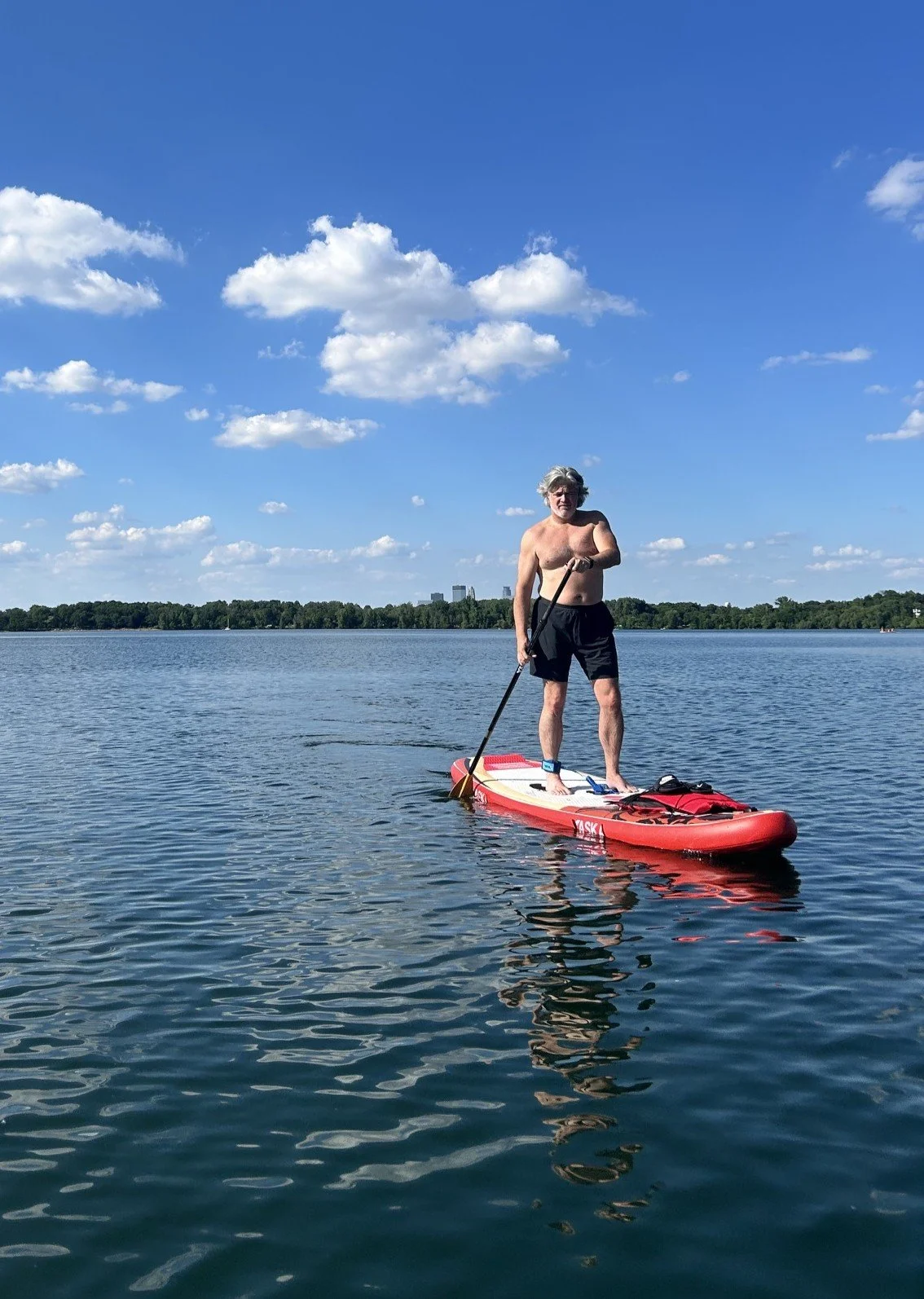 Bryan Koemptgen paddle boarding on Lake Harriet in Minneapolis, Minnesota. Spending time on the water reflects Bryan's appreciation for slowing down, exploring local places, and finding adventure in everyday life.