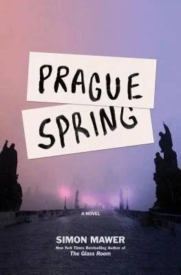 Book cover titled 'Prague Spring' by Simon Mawer, with a background of a purple and pink sky, silhouettes of statues on either side, and a faint cityscape in the distance.