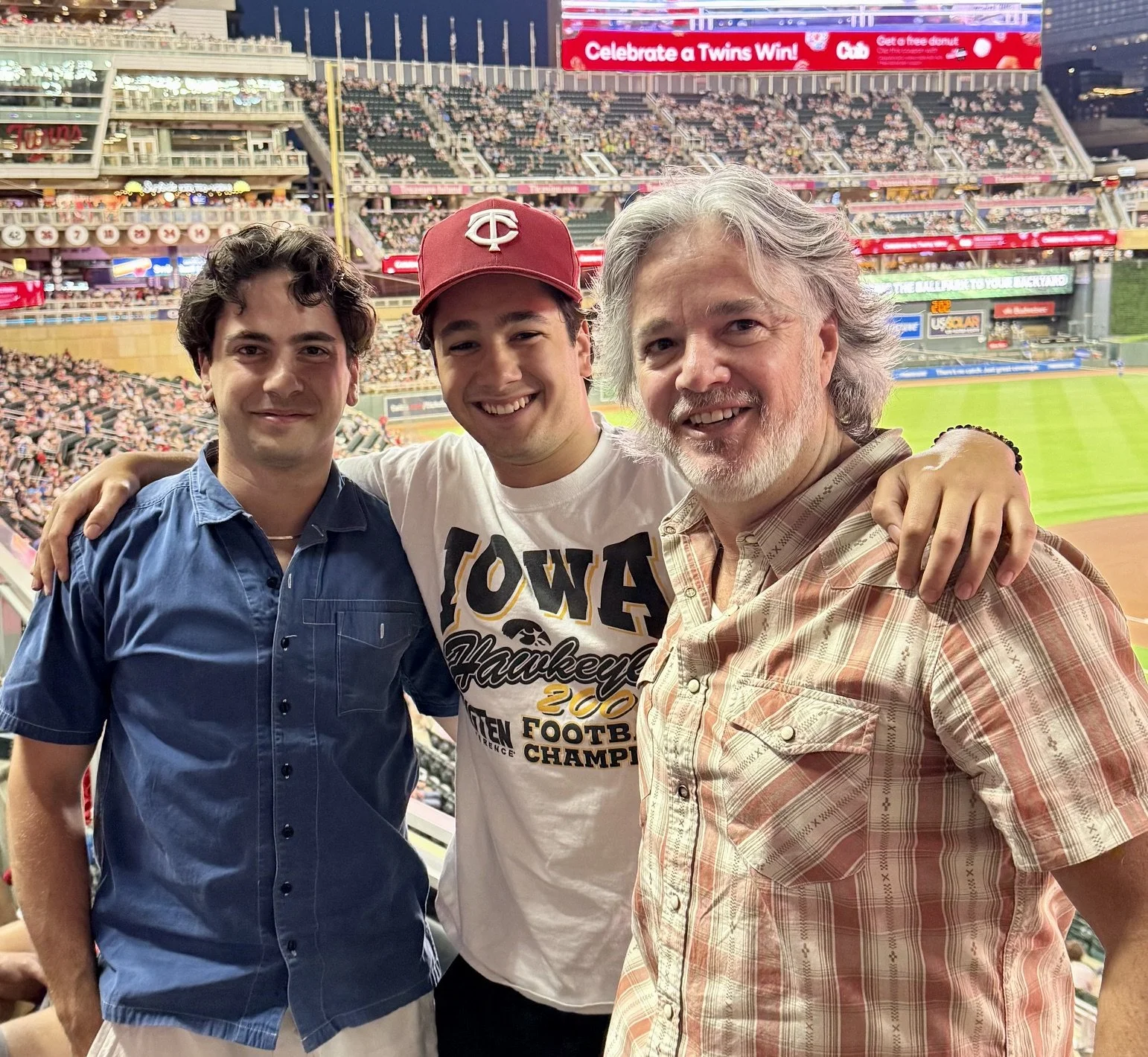 Bryan Koemptgen with his sons Ben and Isaac at Target Field in Minneapolis, Minnesota, cheering on the Minnesota Twins. Baseball has long been a part of family life.