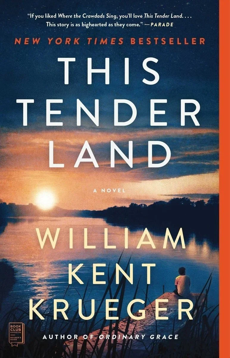 Book cover for 'This Tender Land' by William Kent Krueger, depicting a sunset over a river with a person sitting on the bank, and tall grass in the foreground.