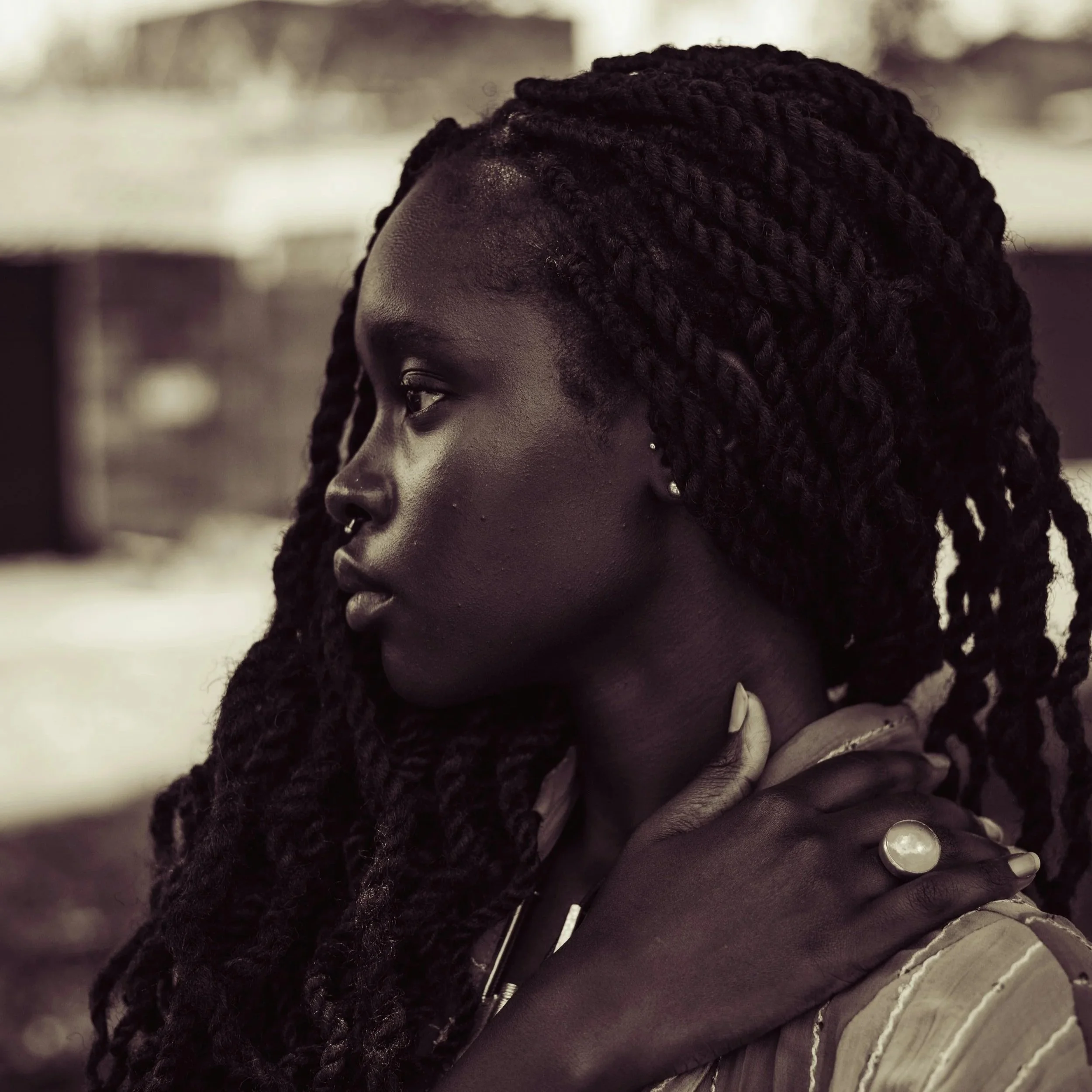 Close-up of a person with dark skin and long, twisted black dreadlocks styled in a thick, rope-like manner.