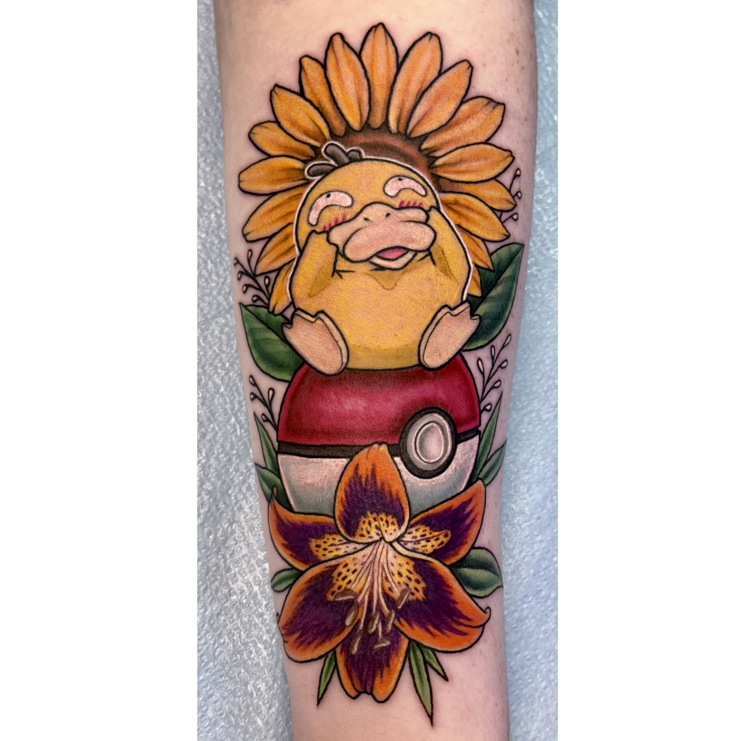 Colorful tattoo of a sunflower and a smiling cartoon-style dog on a person's arm.