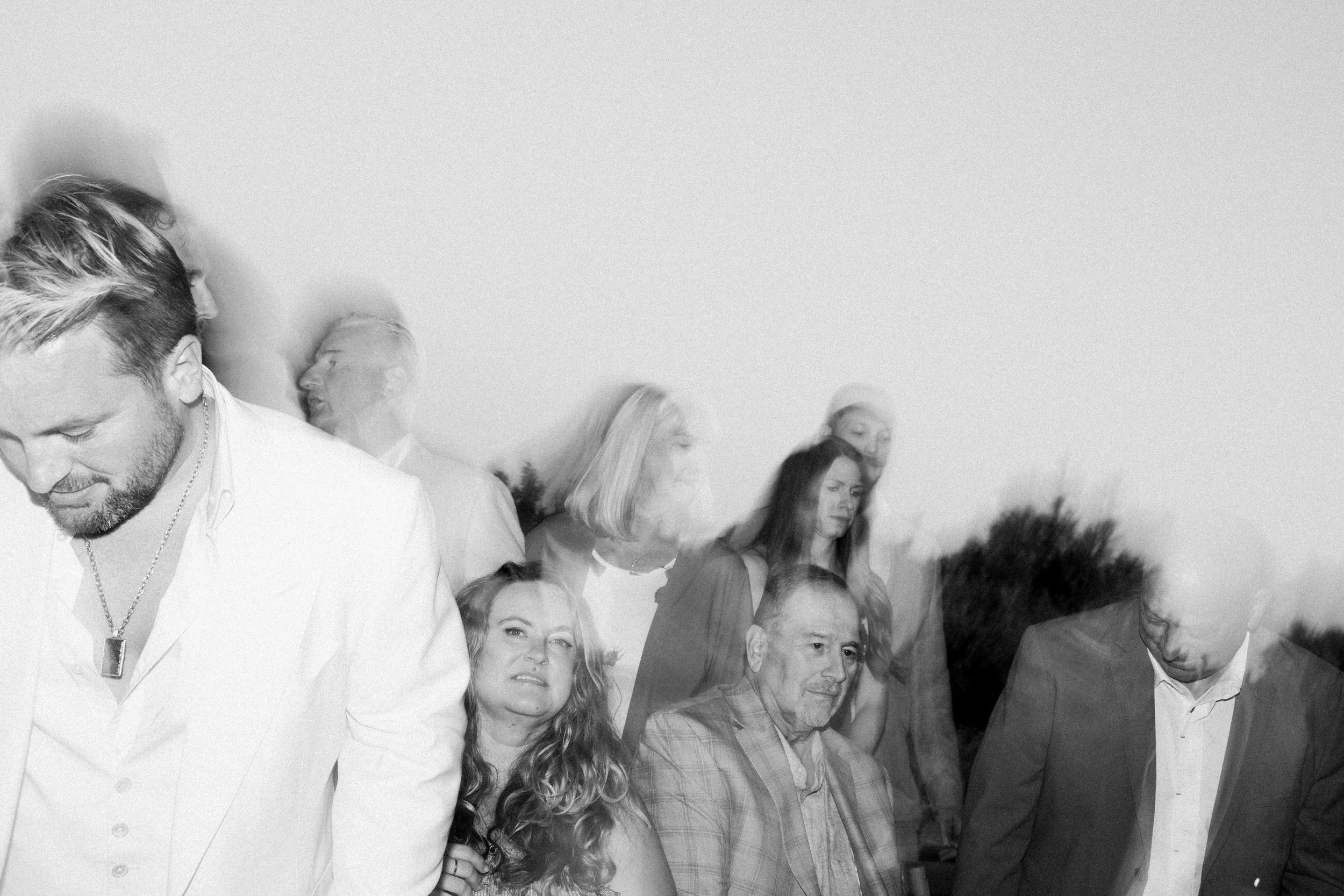 Gruppo di persone che si tengono per mano in cerchio all'aperto durante il tramonto.