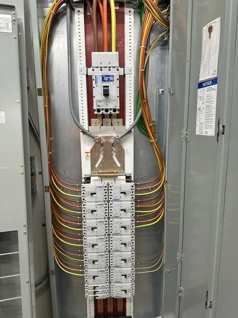 Inside an electrical panel with circuit breakers, wiring, and a main breaker switch.