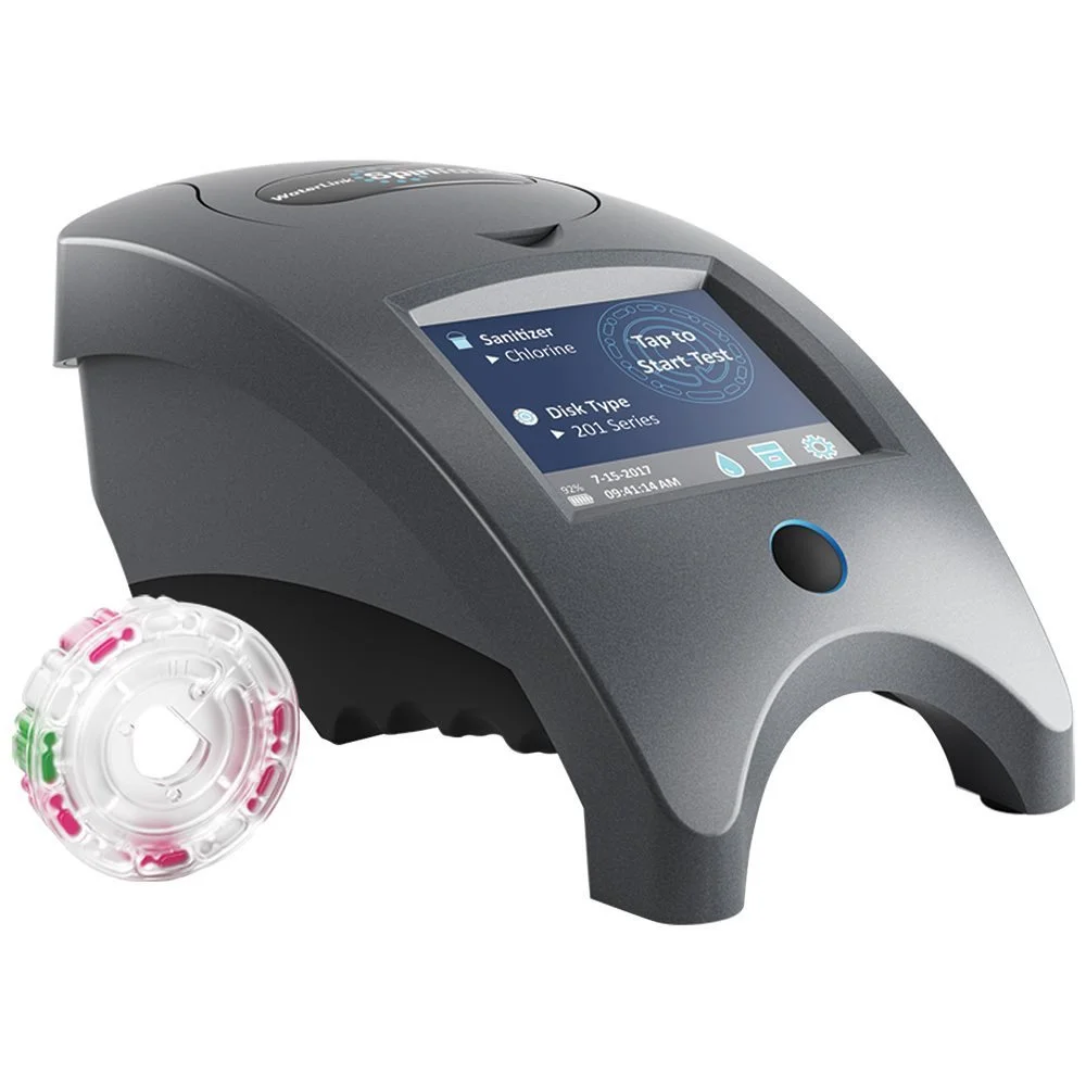A medical diagnostic device with a digital screen displaying test options, a circular testing wheel with pink and green sections, and a gray body.