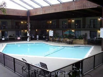 Indoor hotel swimming pool area with lounge chairs and lighting